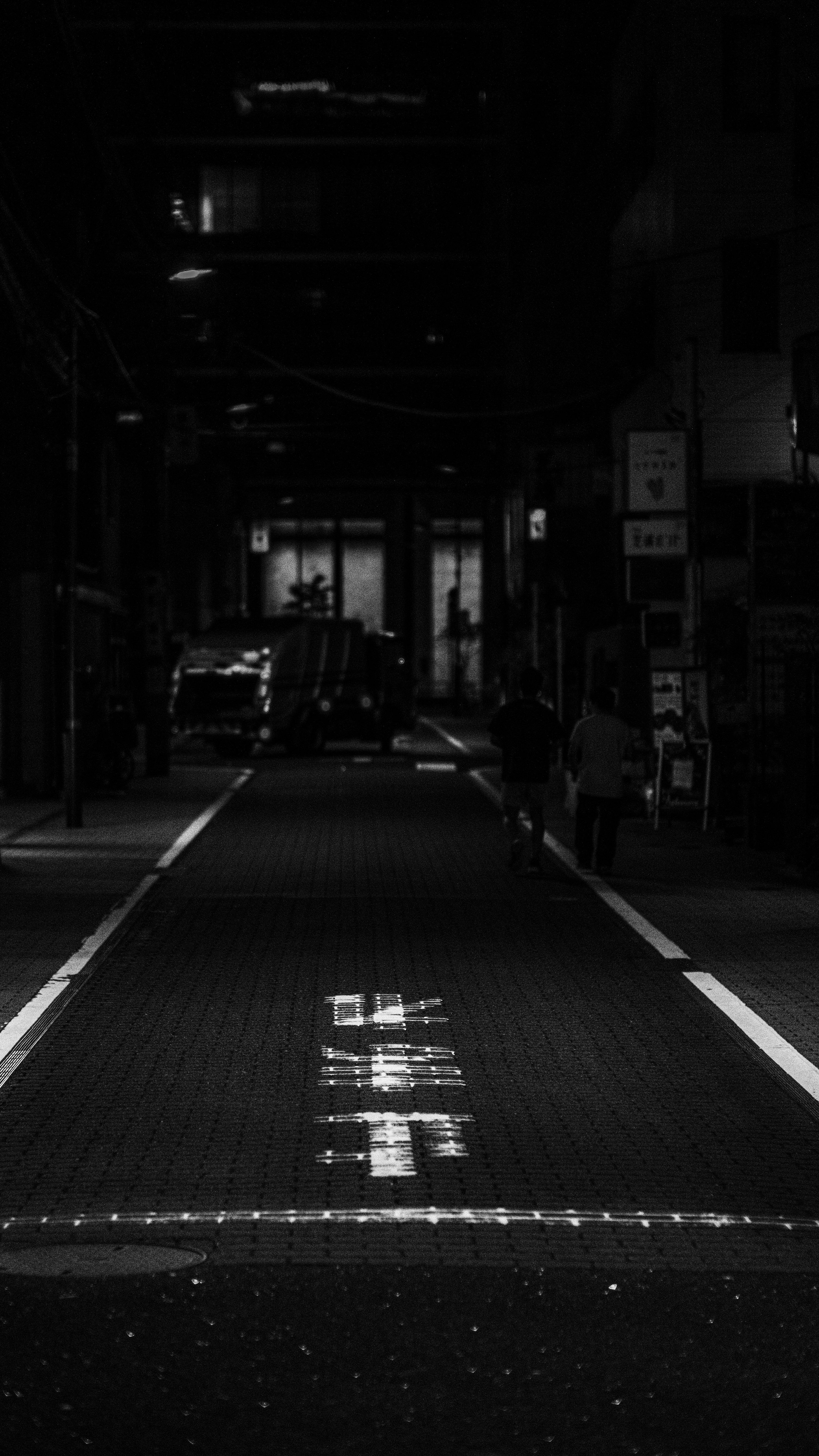 3000x5334 Dark street with japanese characters on the pavement. photo