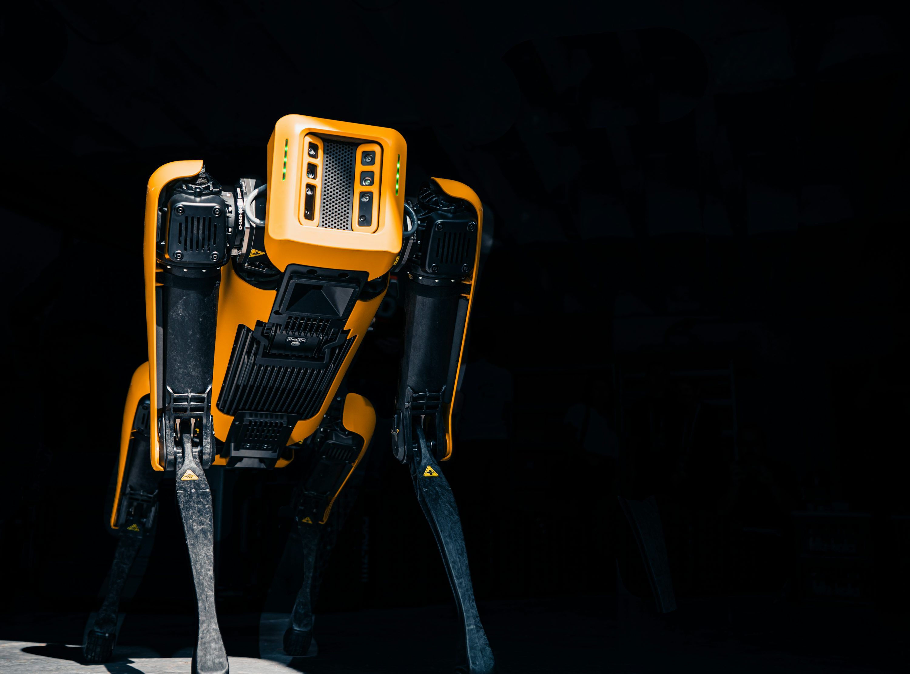 3000x2221 A yellow and black robot standing in the dark photo