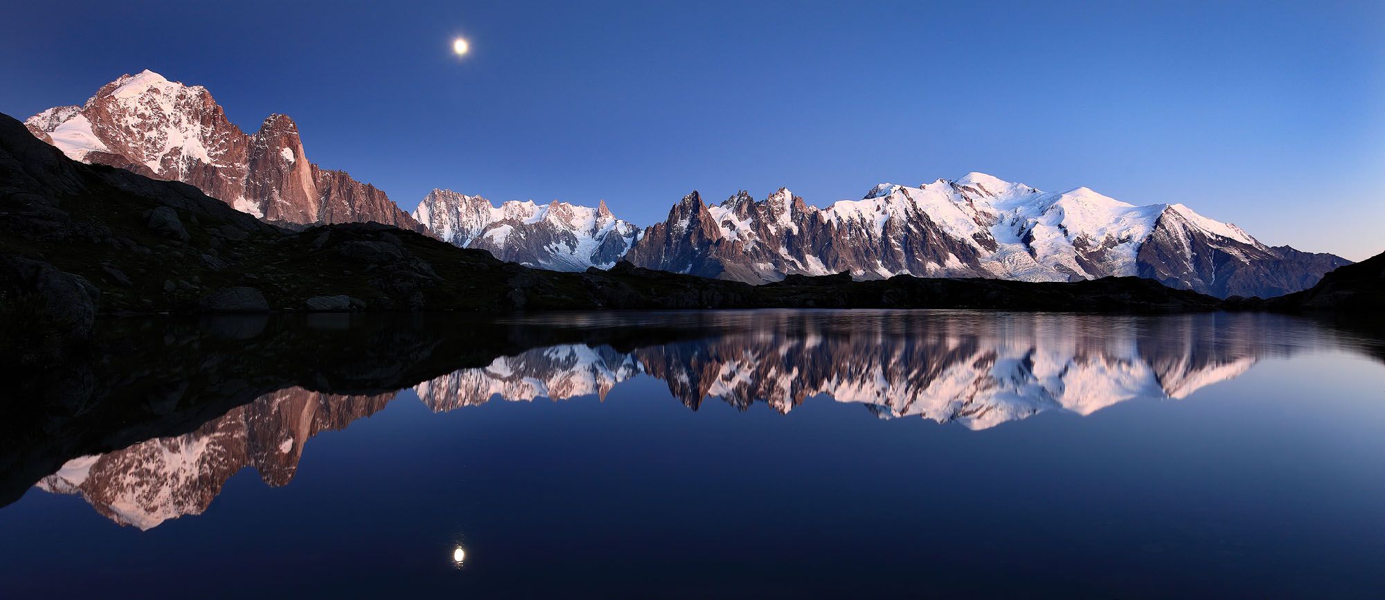 2000x867 Mont Blanc reflects at lake Cheserys with rising moon and stars