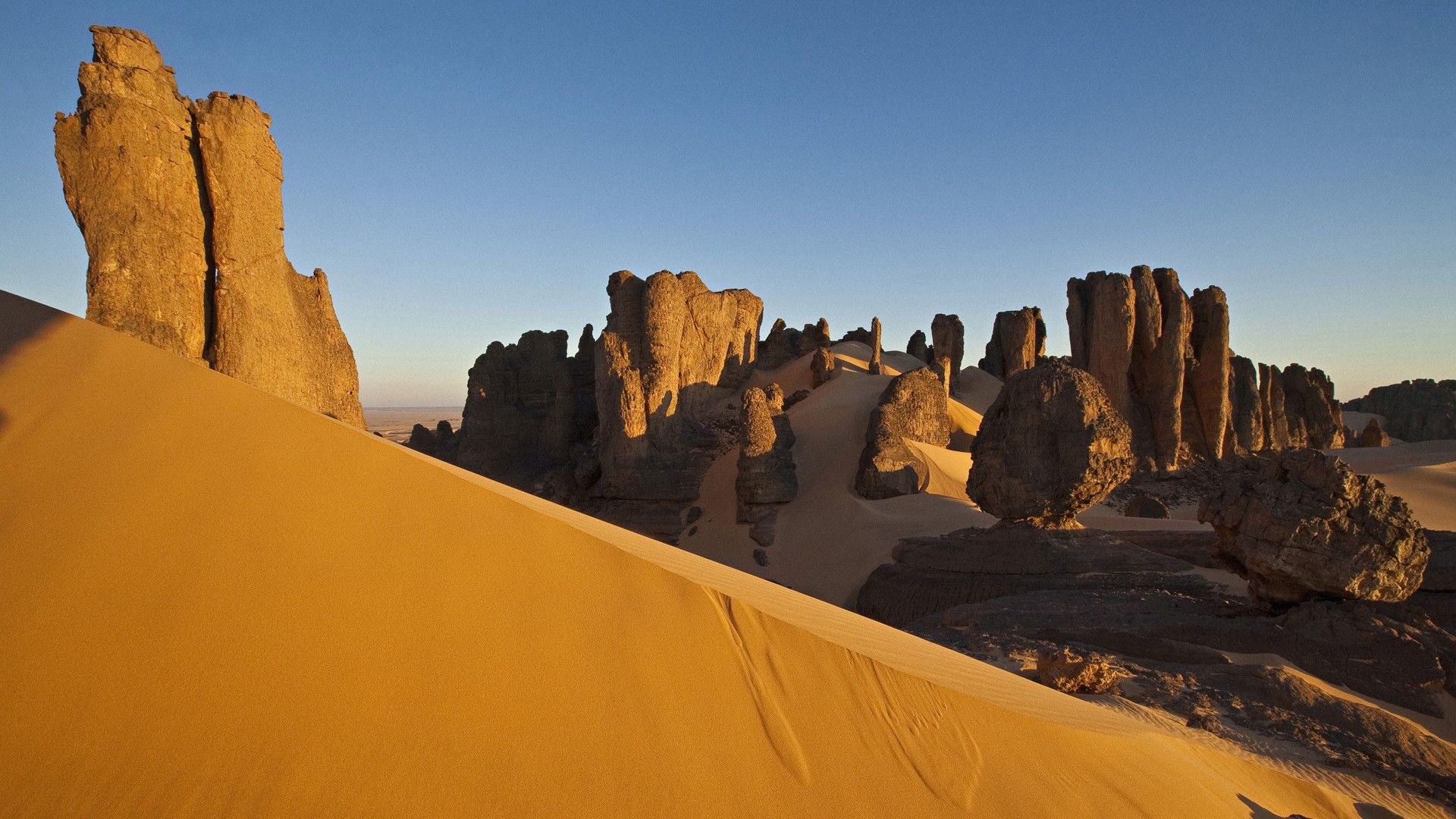 1920x1080 Rock formations and dunes at Tin Akachaker desert (Citadel), Hoggar, Ahaggar Mountains, Algeria. Windows Spotlight Image