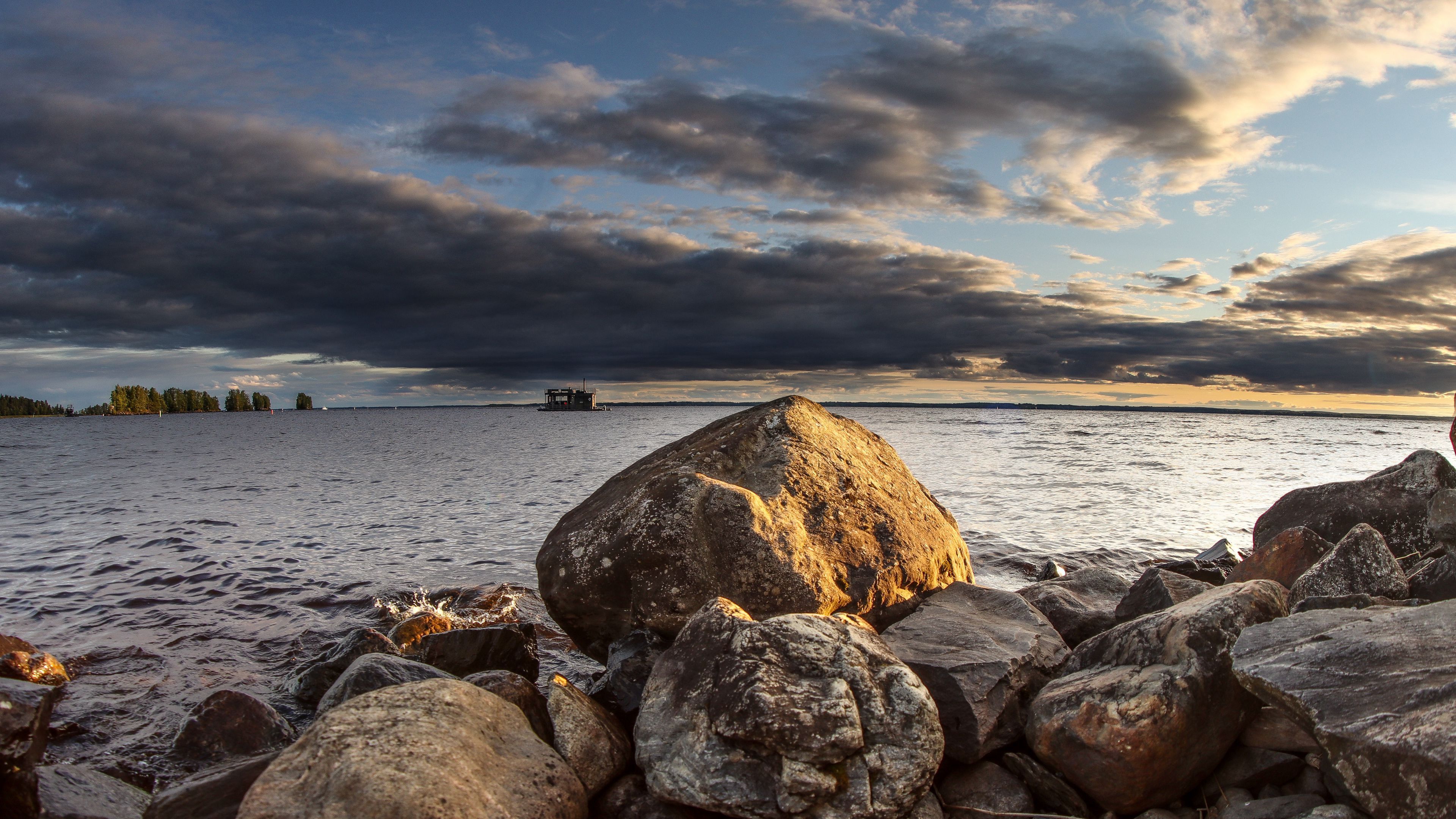 3840x2160 Big Stones Ocean Background Under Black White Clouds Blue Sky 4K HD Nature Wallpaper