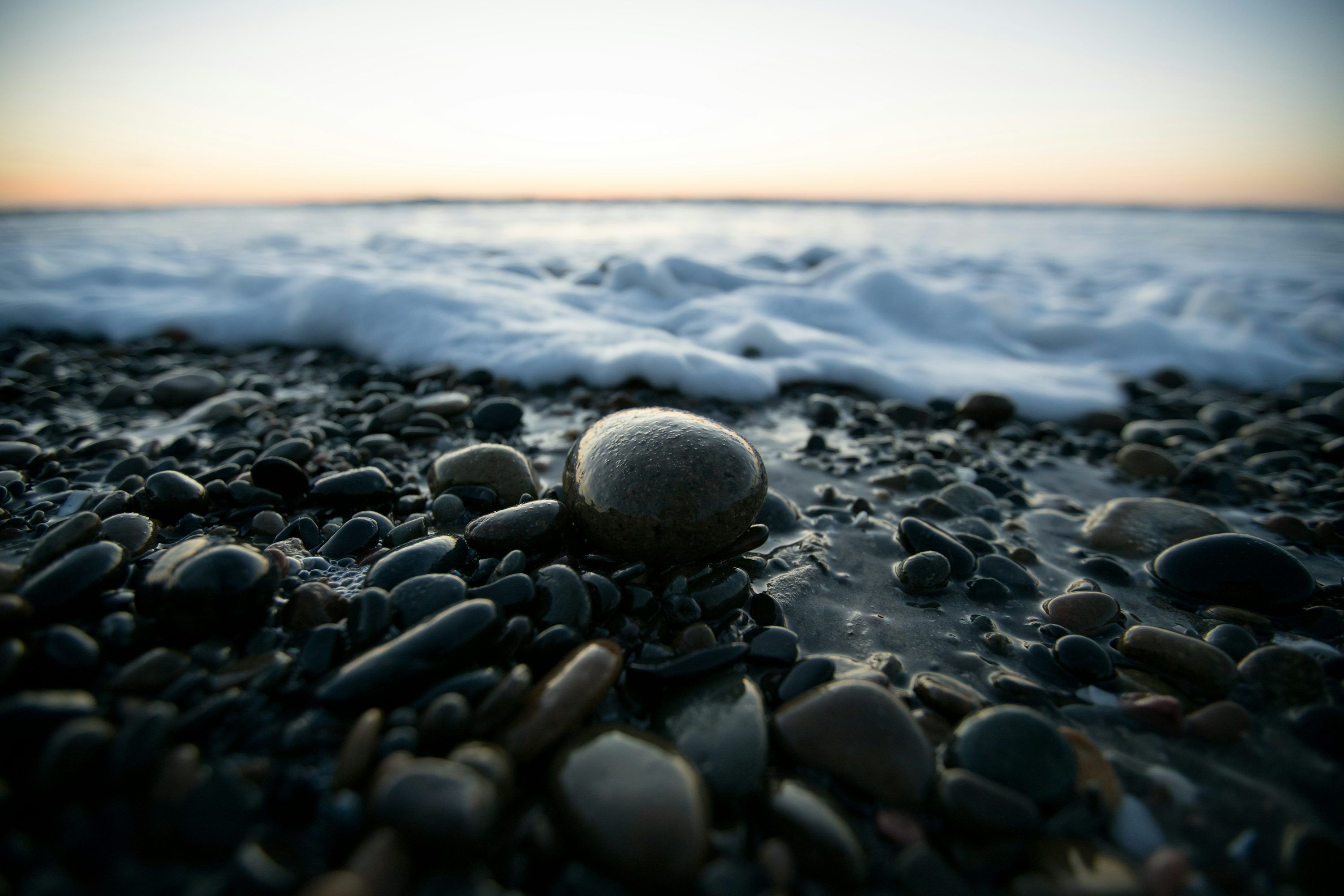 3000x2001 A close up of rocks on a beach near the ocean photo