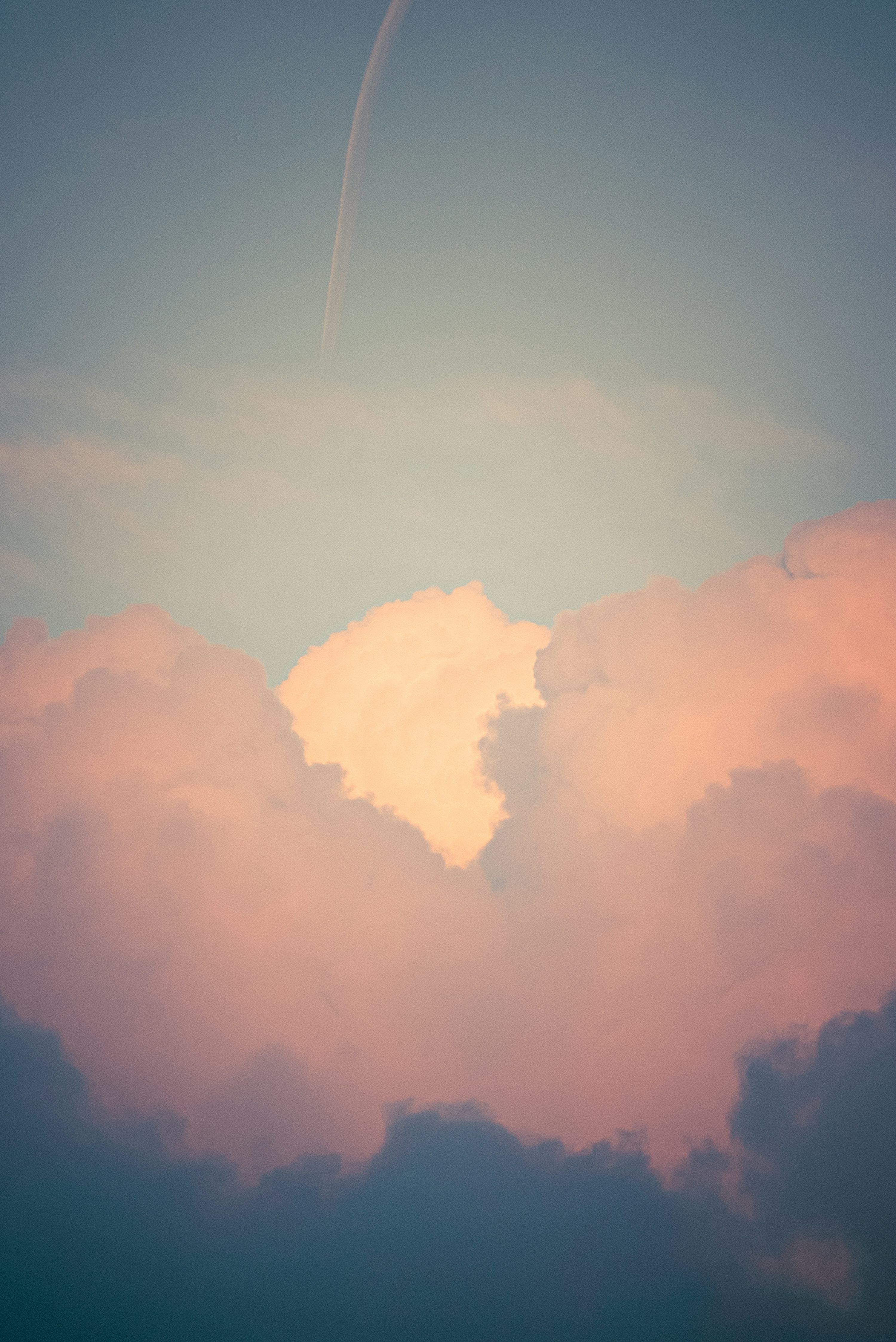 3000x4491 Soft pink and orange clouds against a blue sky. photo