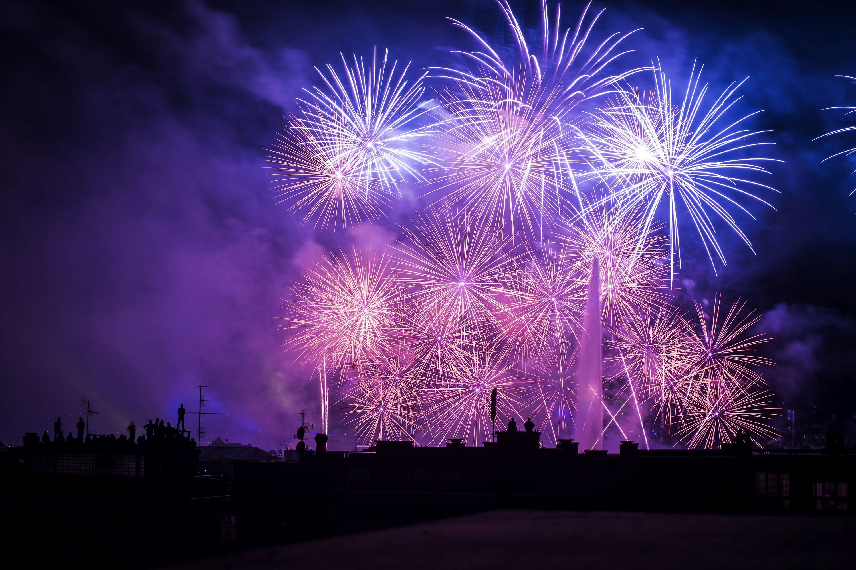 3000x2000 Silhouette of buildings with purple and pink fireworks display photo