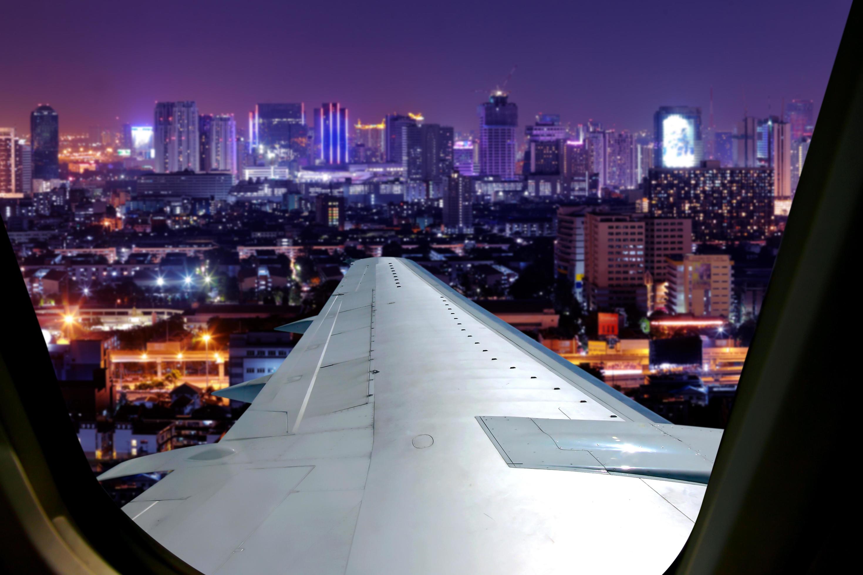 2940x1960 Evening flight on twilight sky, amazing view from the window plane. Window seat on airplane overlooking city at night view
