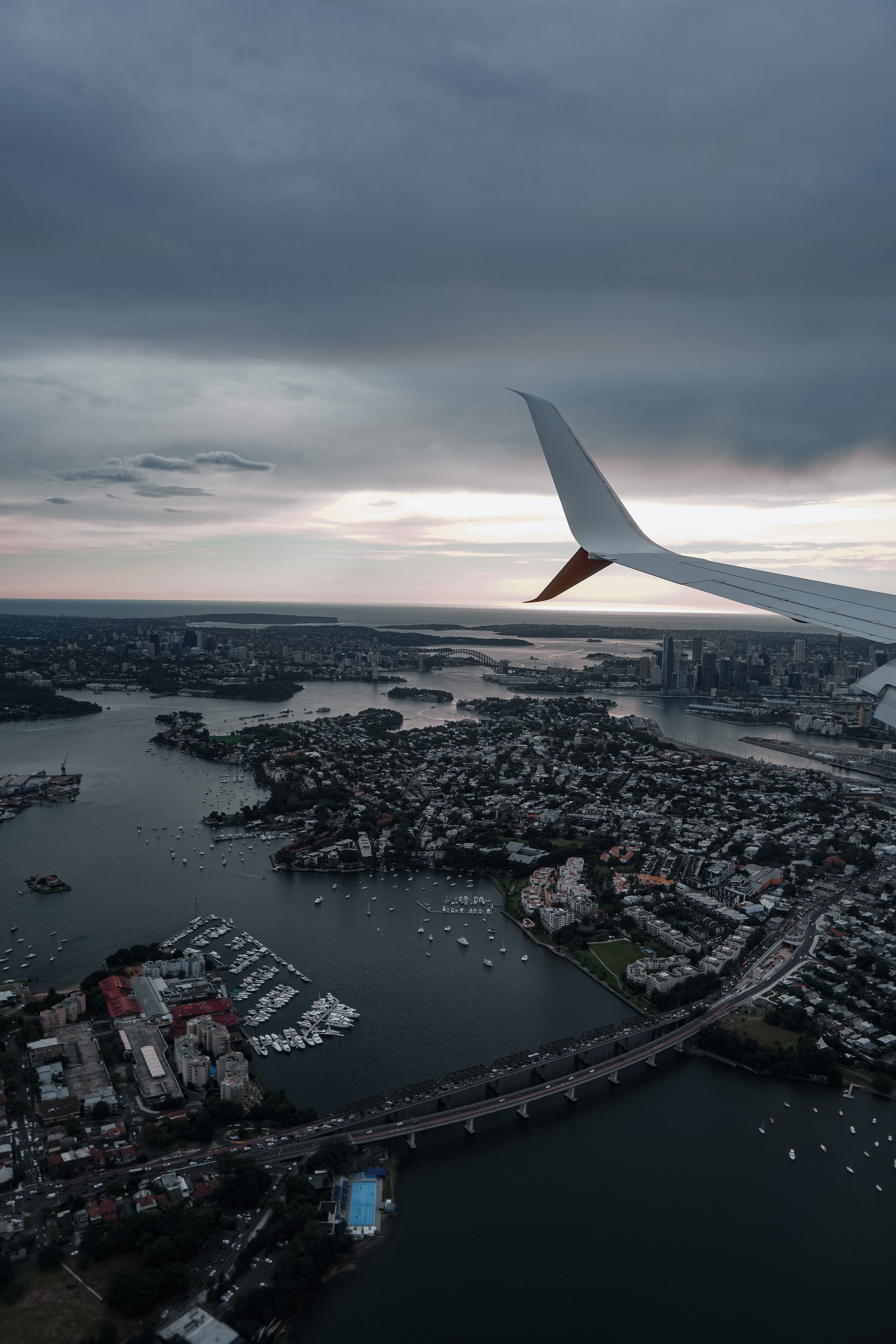 4000x6000 White Airplane Wing over City Under Gloomy Sky · Free