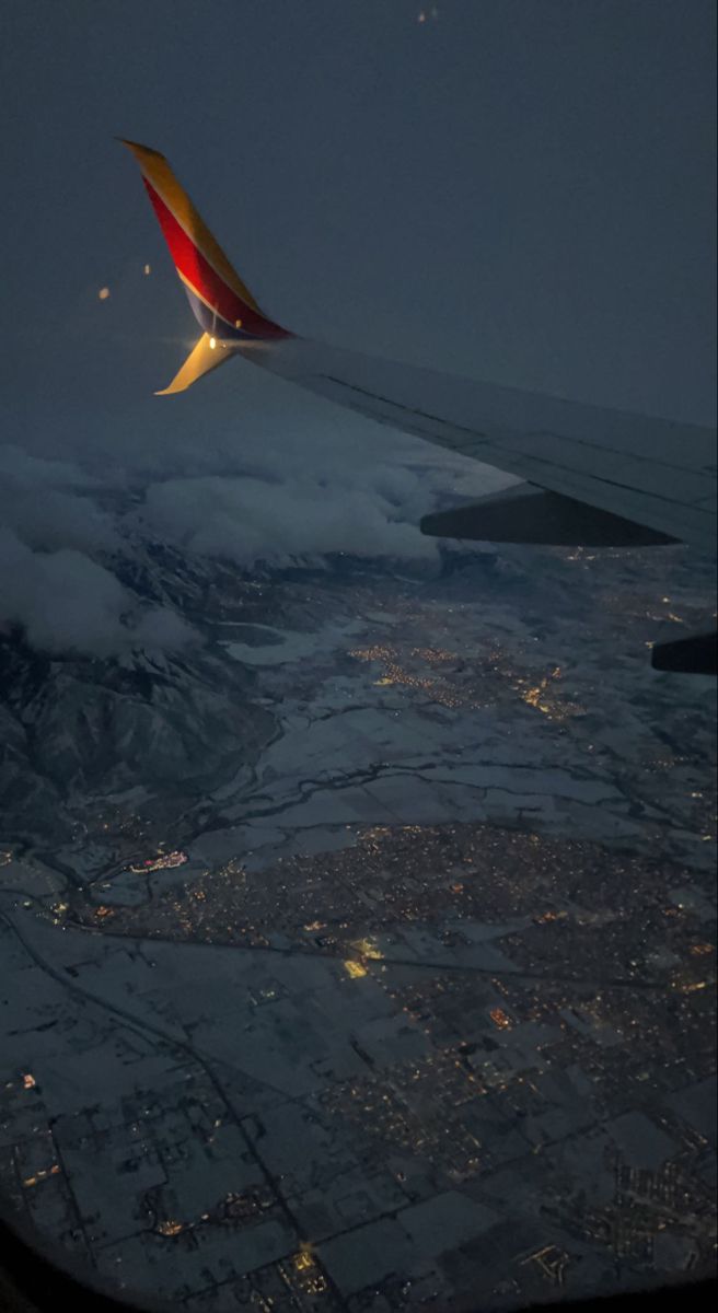 656x1200 Snowy Salt Lake City Night Flight. Airplane window perspective, Airplane wing over city at night, Night flight experience tips