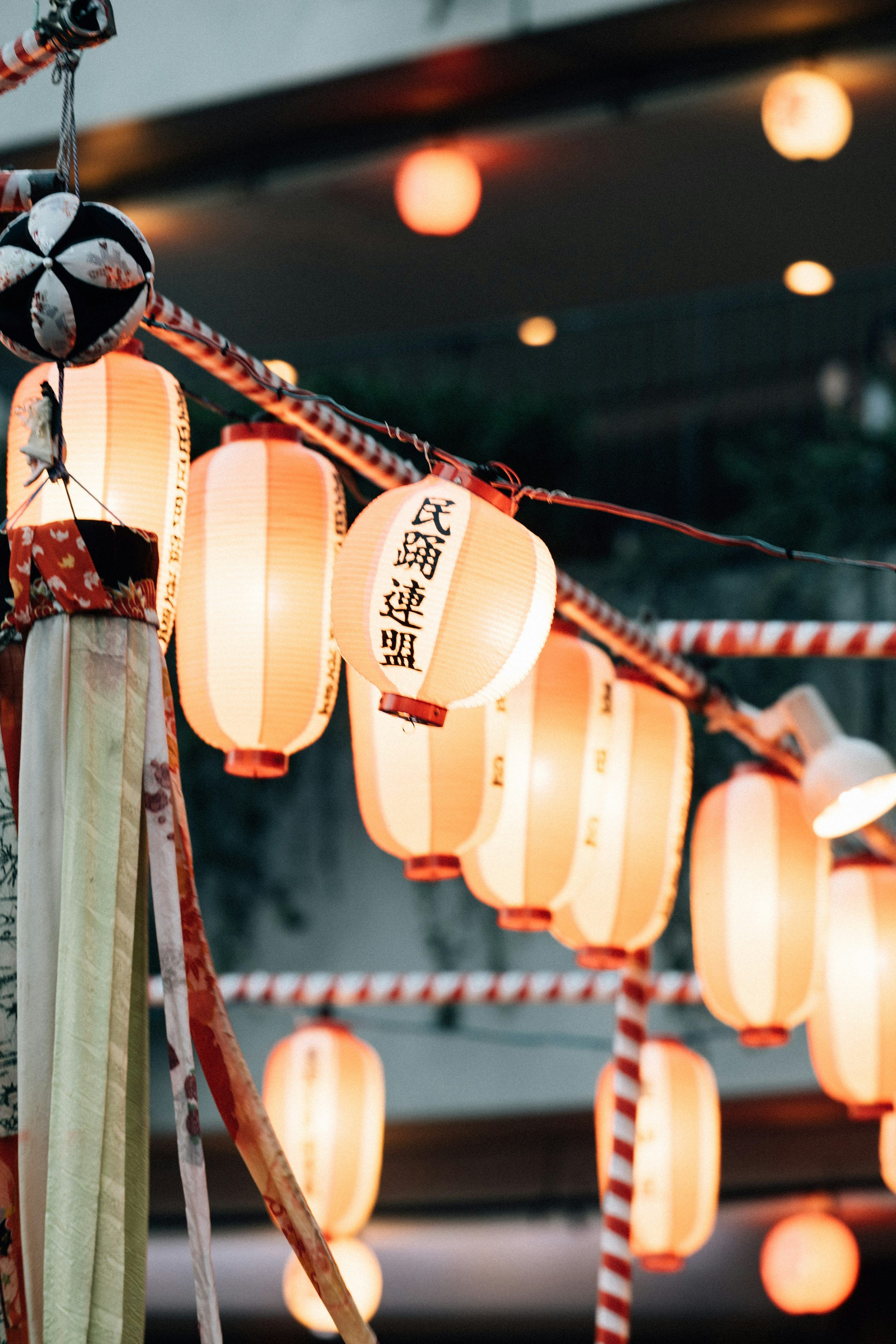 3000x4499 A bunch of paper lanterns hanging from a pole photo