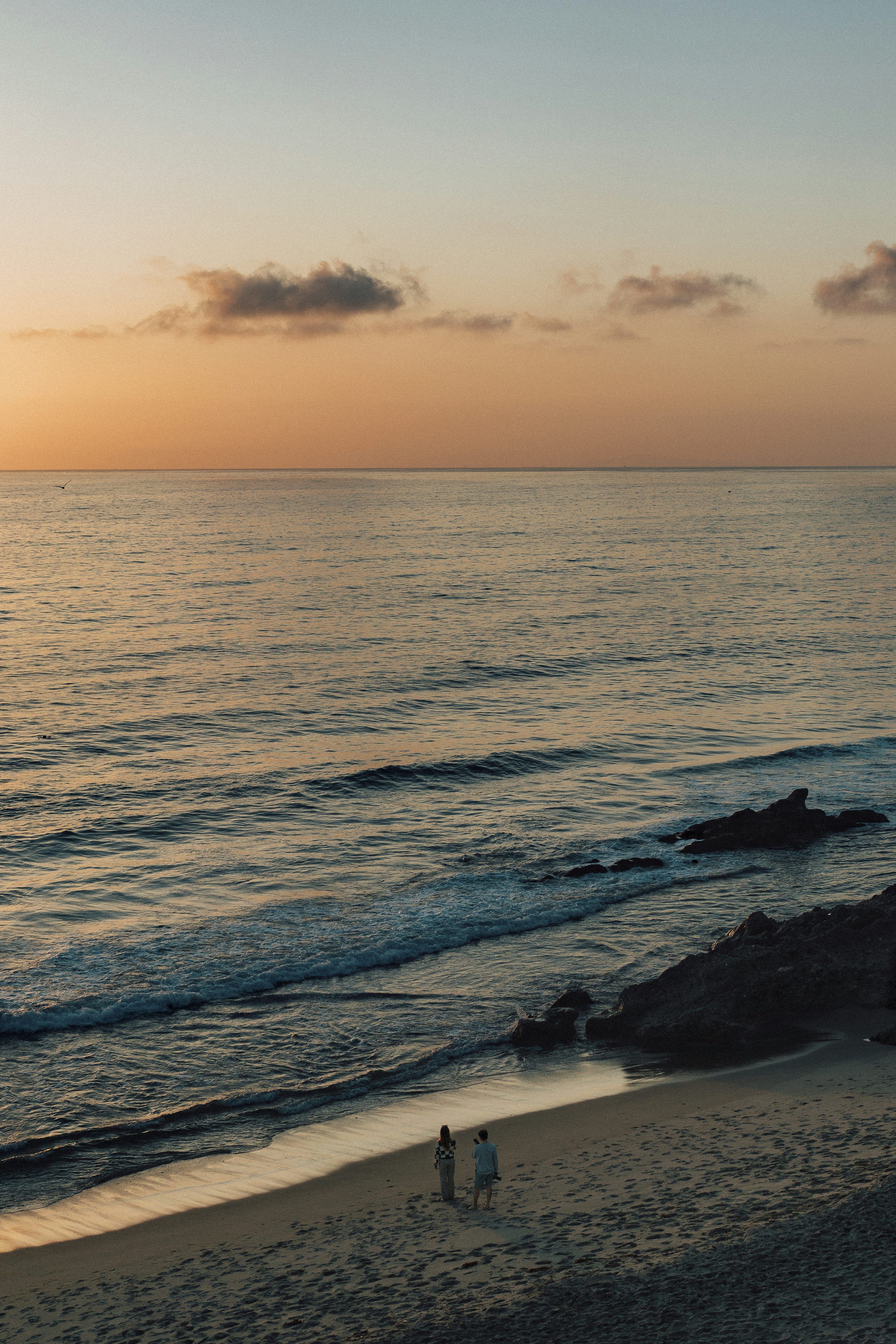 3000x4498 Two people walking on the beach at sunset photo