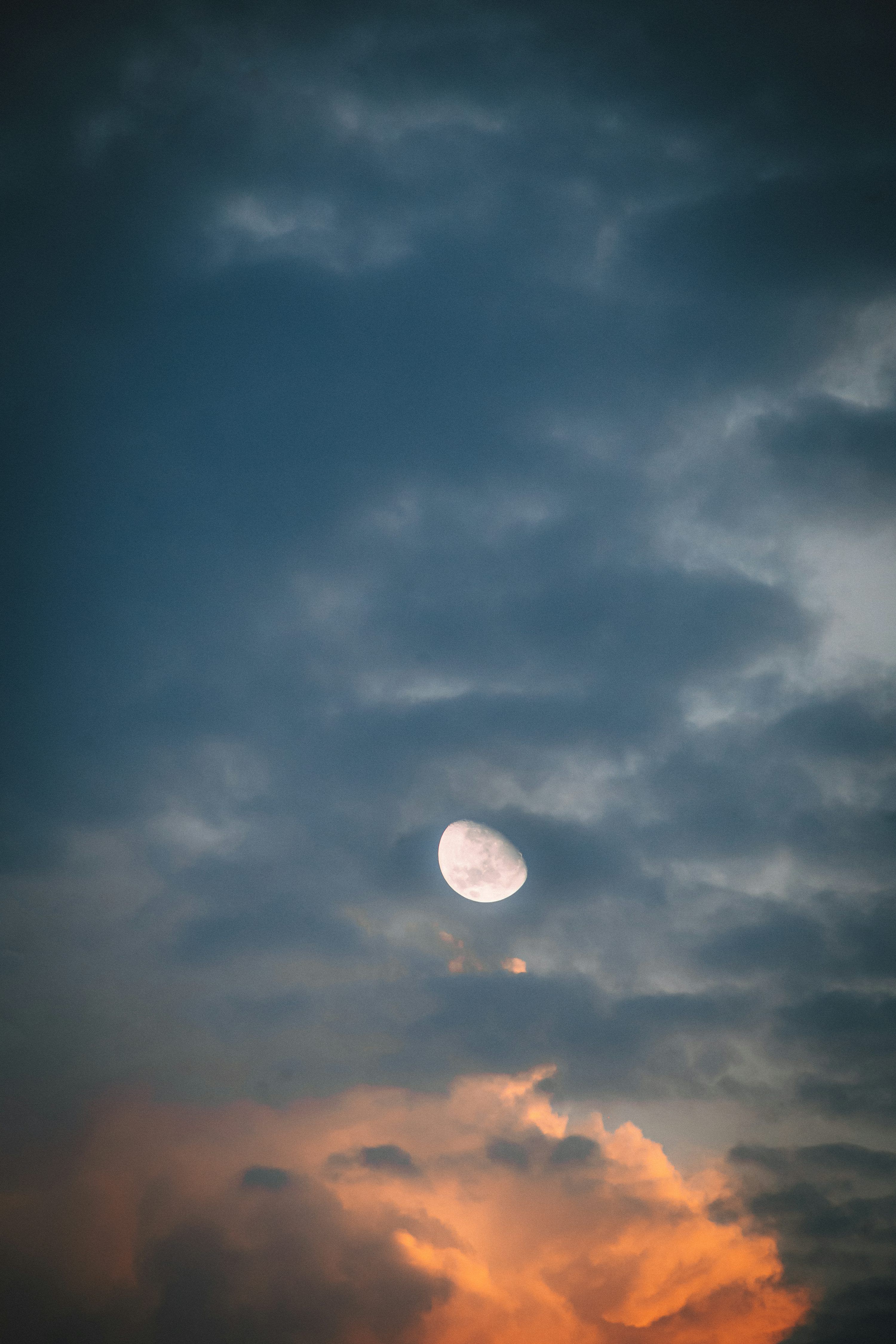 3000x4500 Half moon visible through dramatic cloudy sky photo