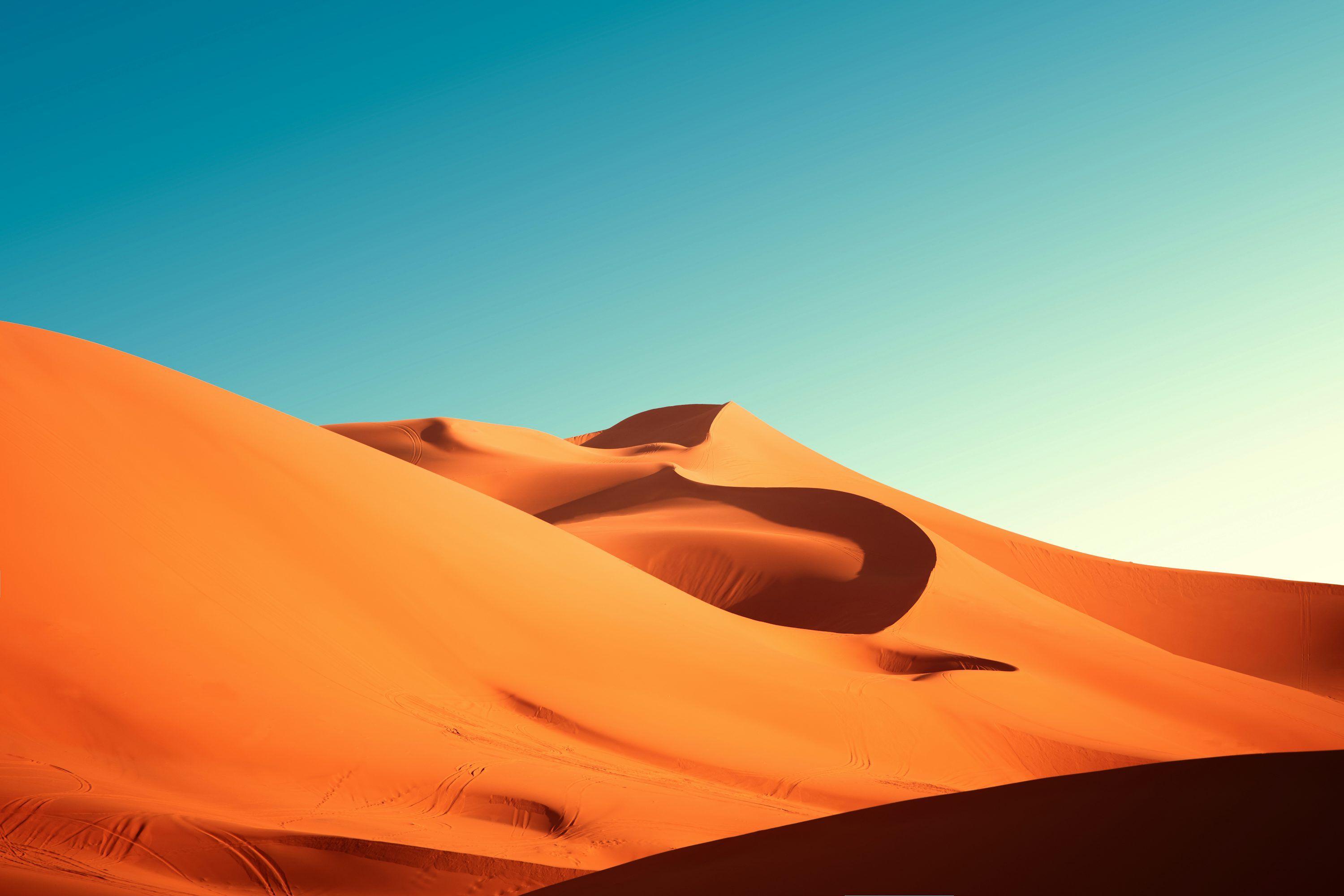 3000x2000 A group of sand dunes with a blue sky in the background photo