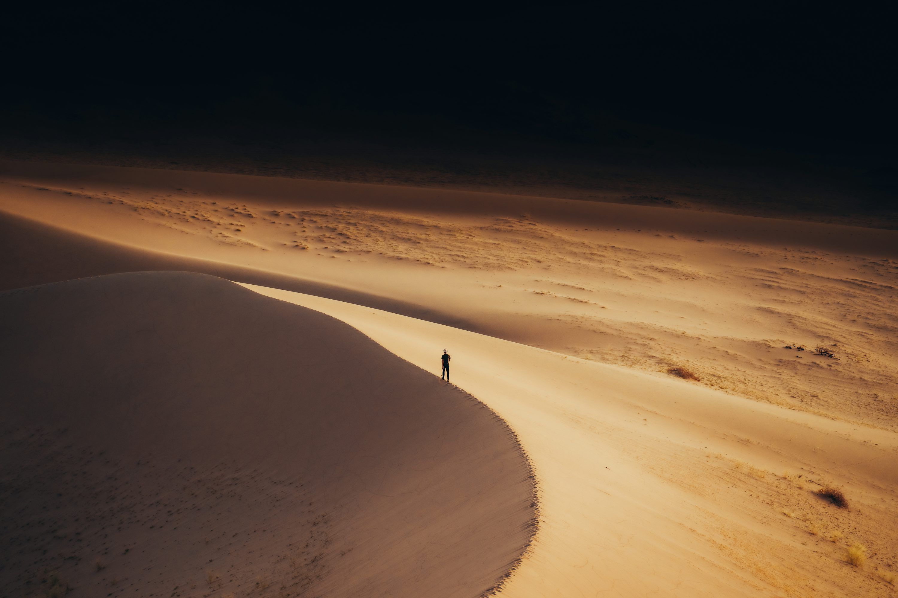 3000x2000 A lone person standing in the middle of a desert photo