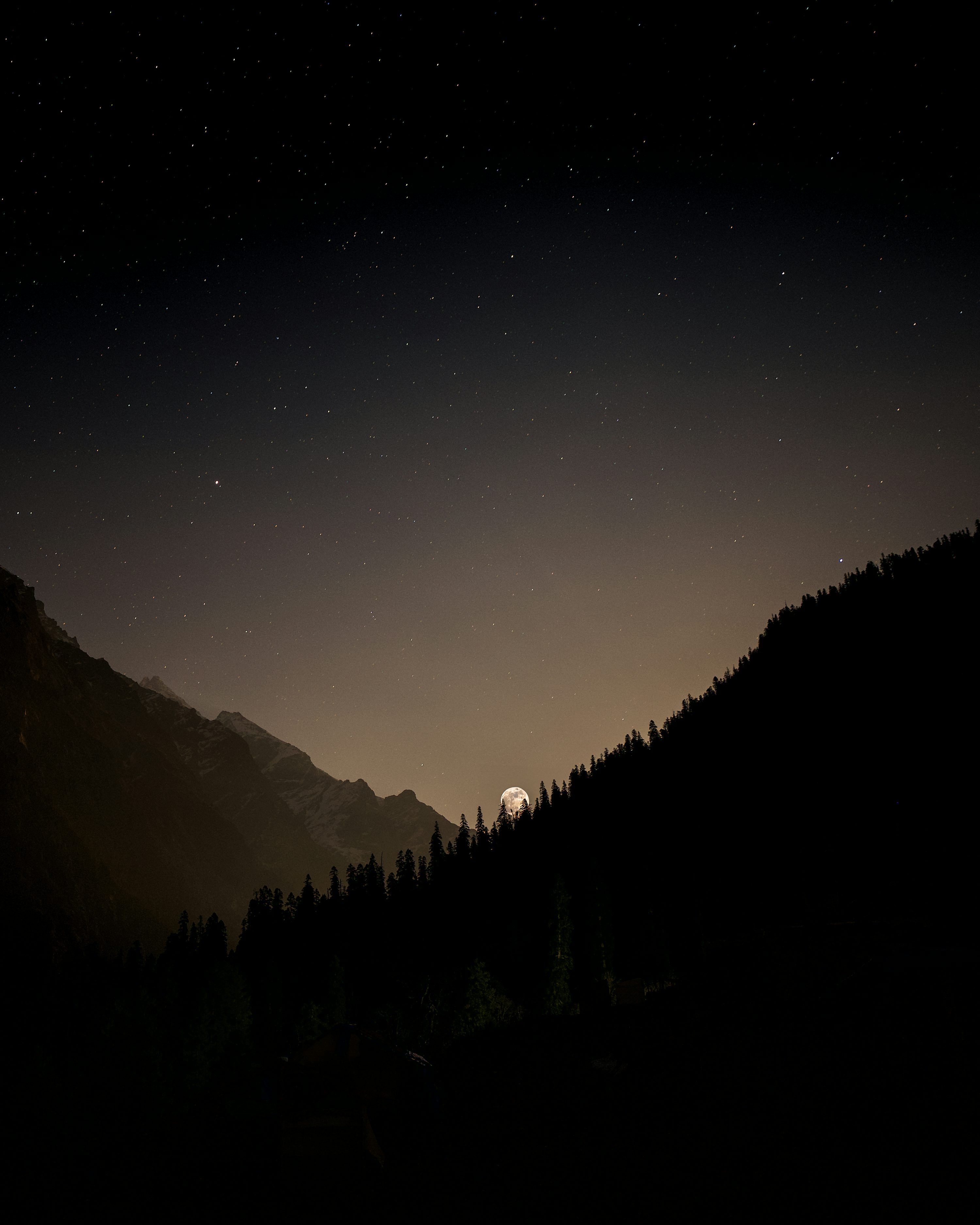 3000x3750 A full moon rises over a mountain range photo