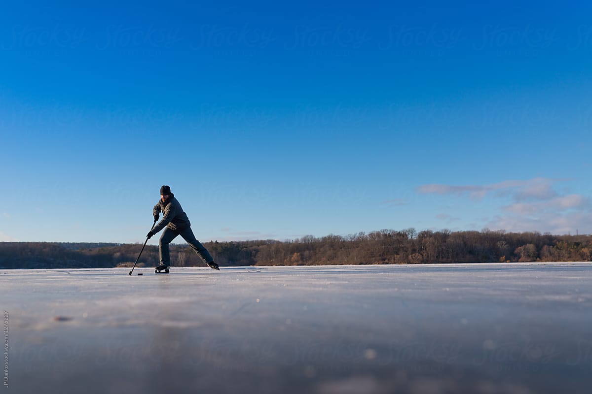 1200x800 Man Skating Outdoors Playing Ice Hockey on Frozen Pond in Winter