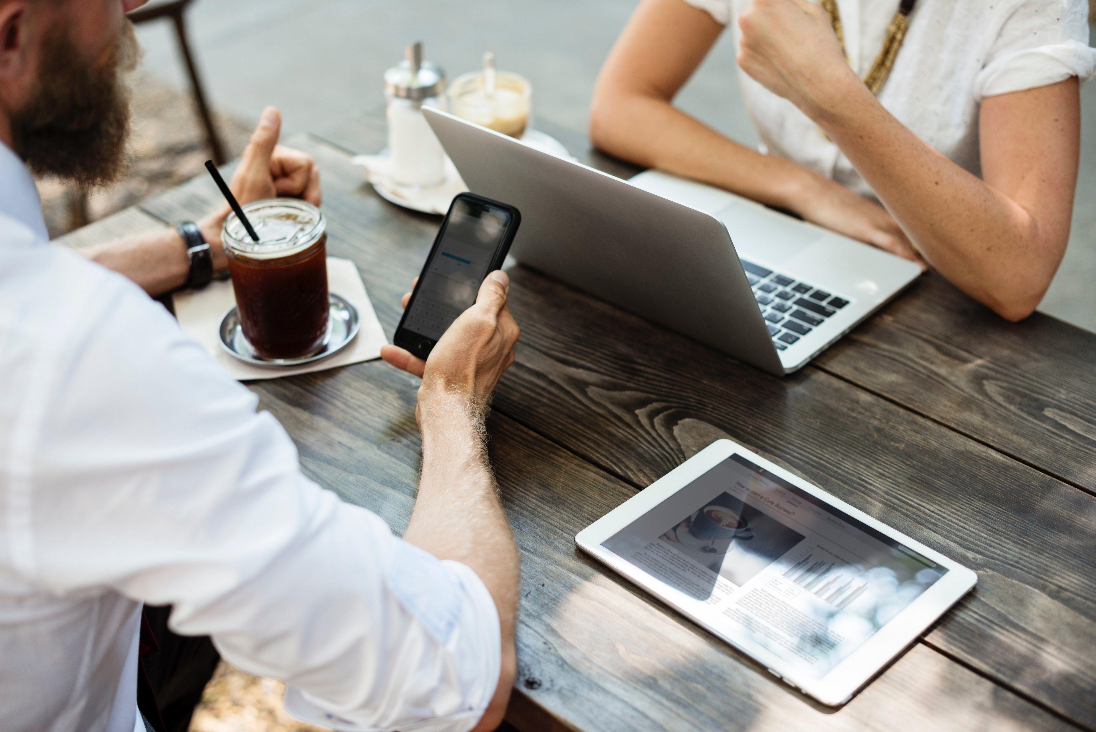 3840x2563 two business people sitting at a coffee shop table with a laptop a