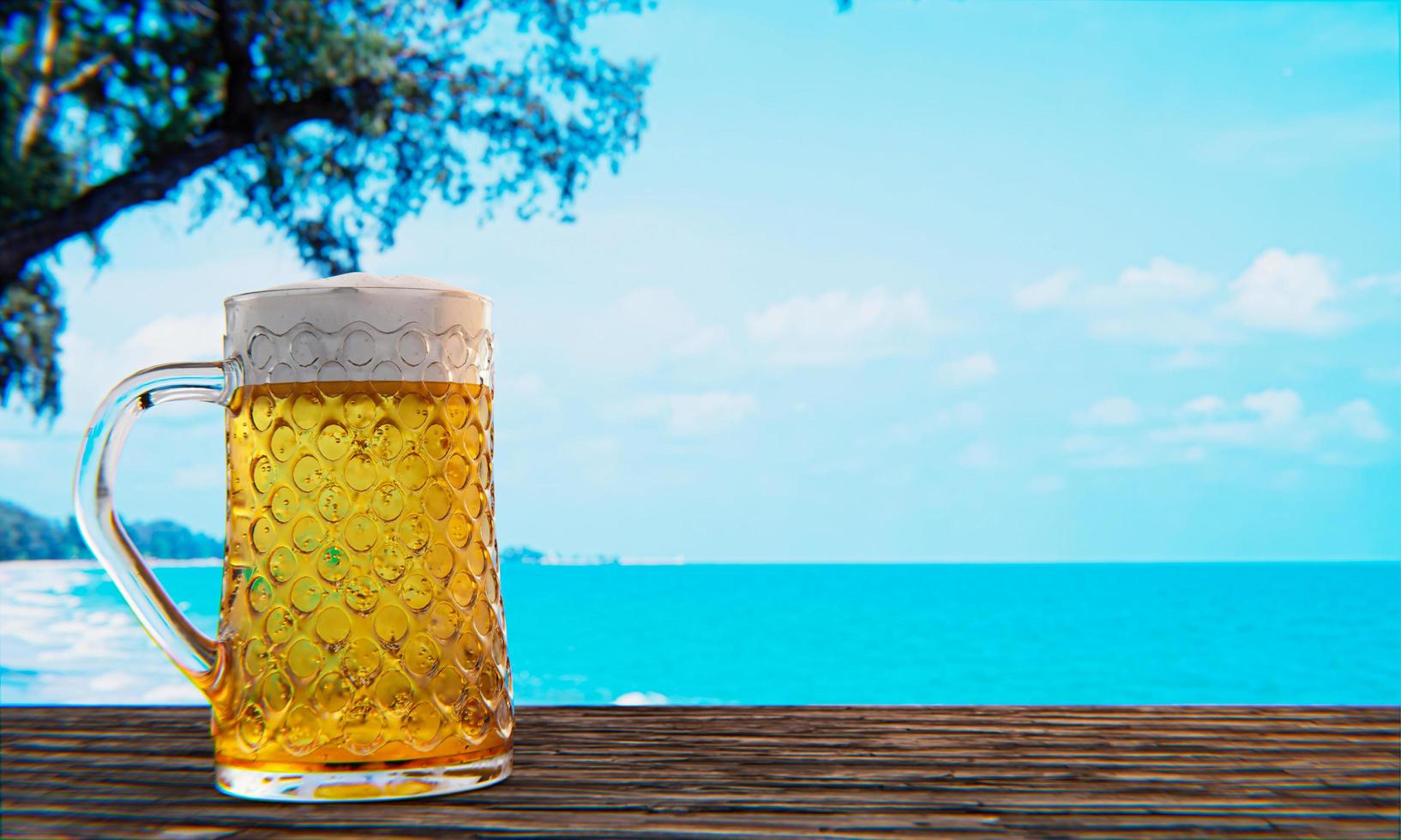 1634x980 Draft or craft beer in a tall clear glass With beer foam on top And there are bubbles in the glass. Cold beer in a glass, placed on a wooden table on