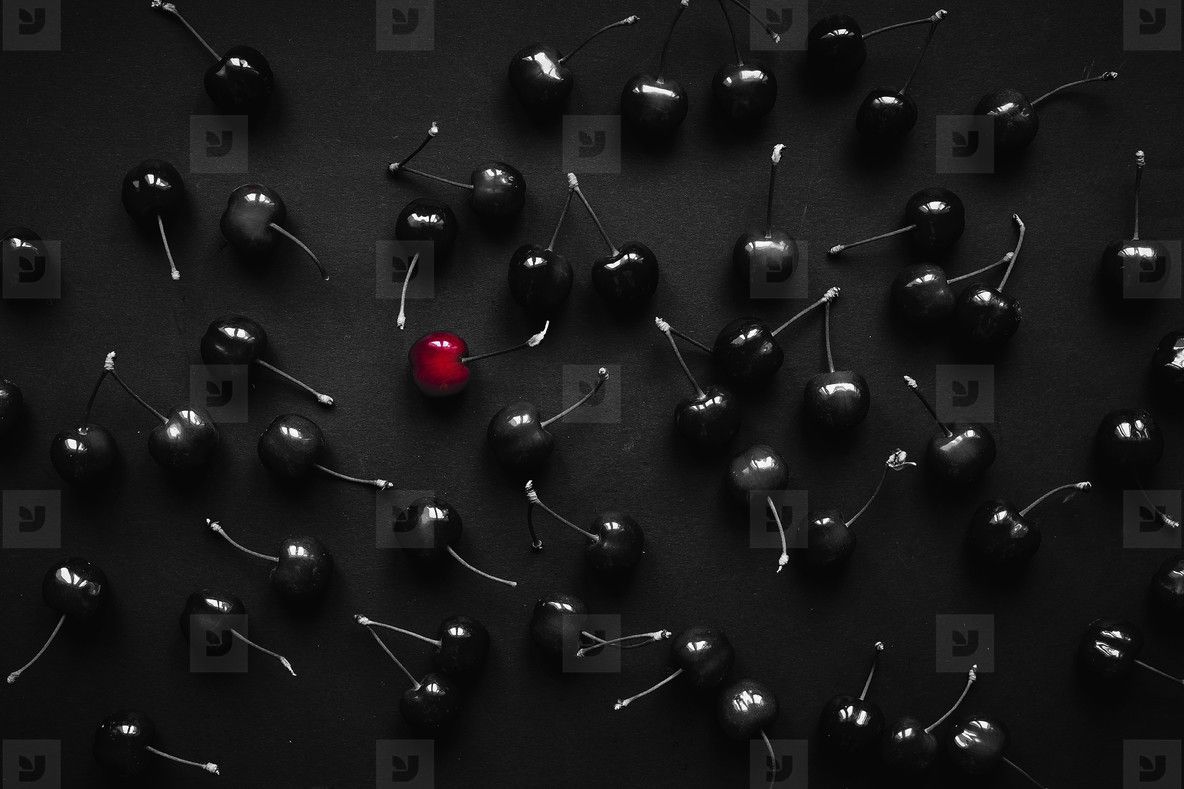 1184x789 Red Cherry On A Background Of Black Cherries. Concept Exclusive Photo