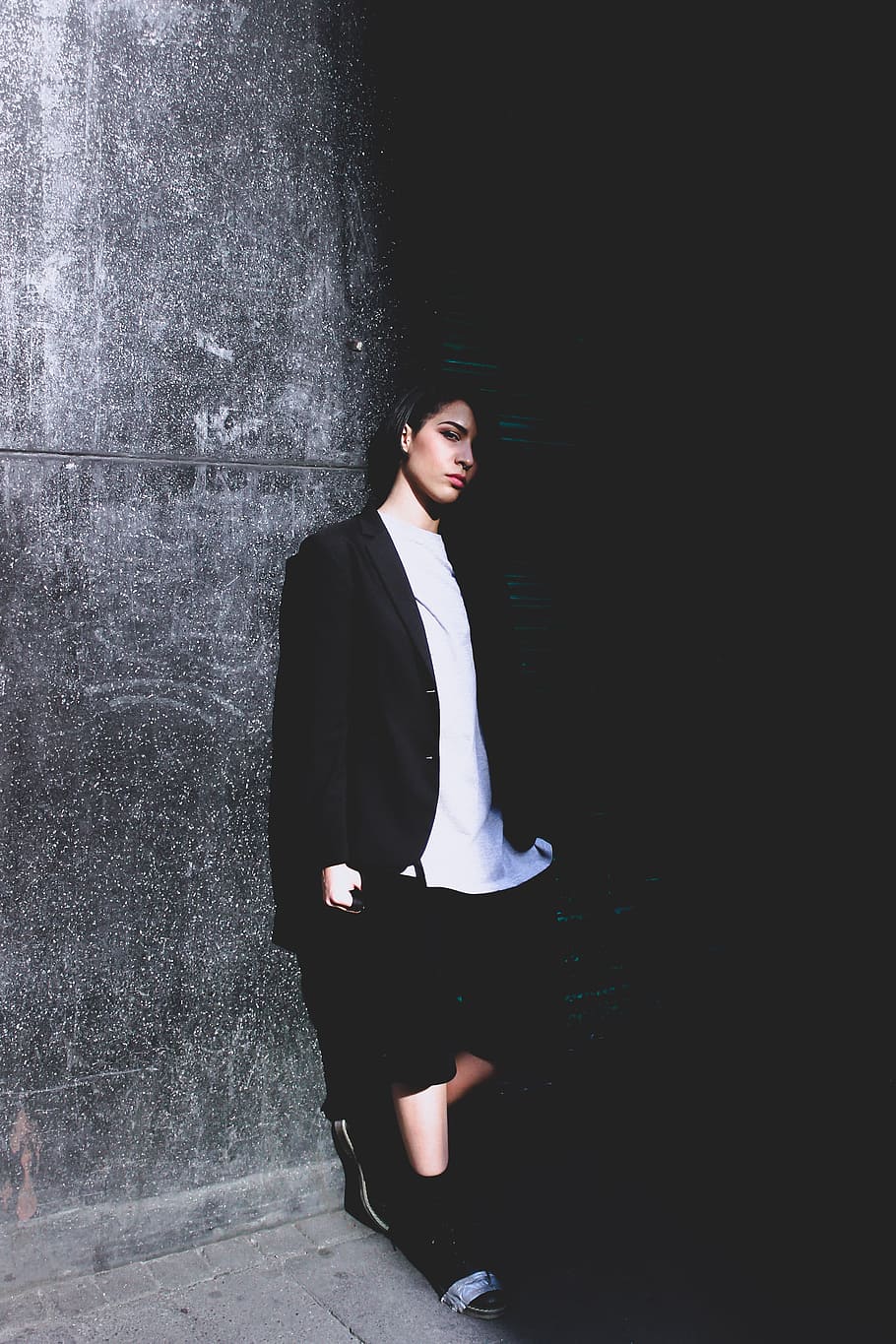 910x1365 HD wallpaper: woman leaning on wall, woman wearing black coat and white shirt