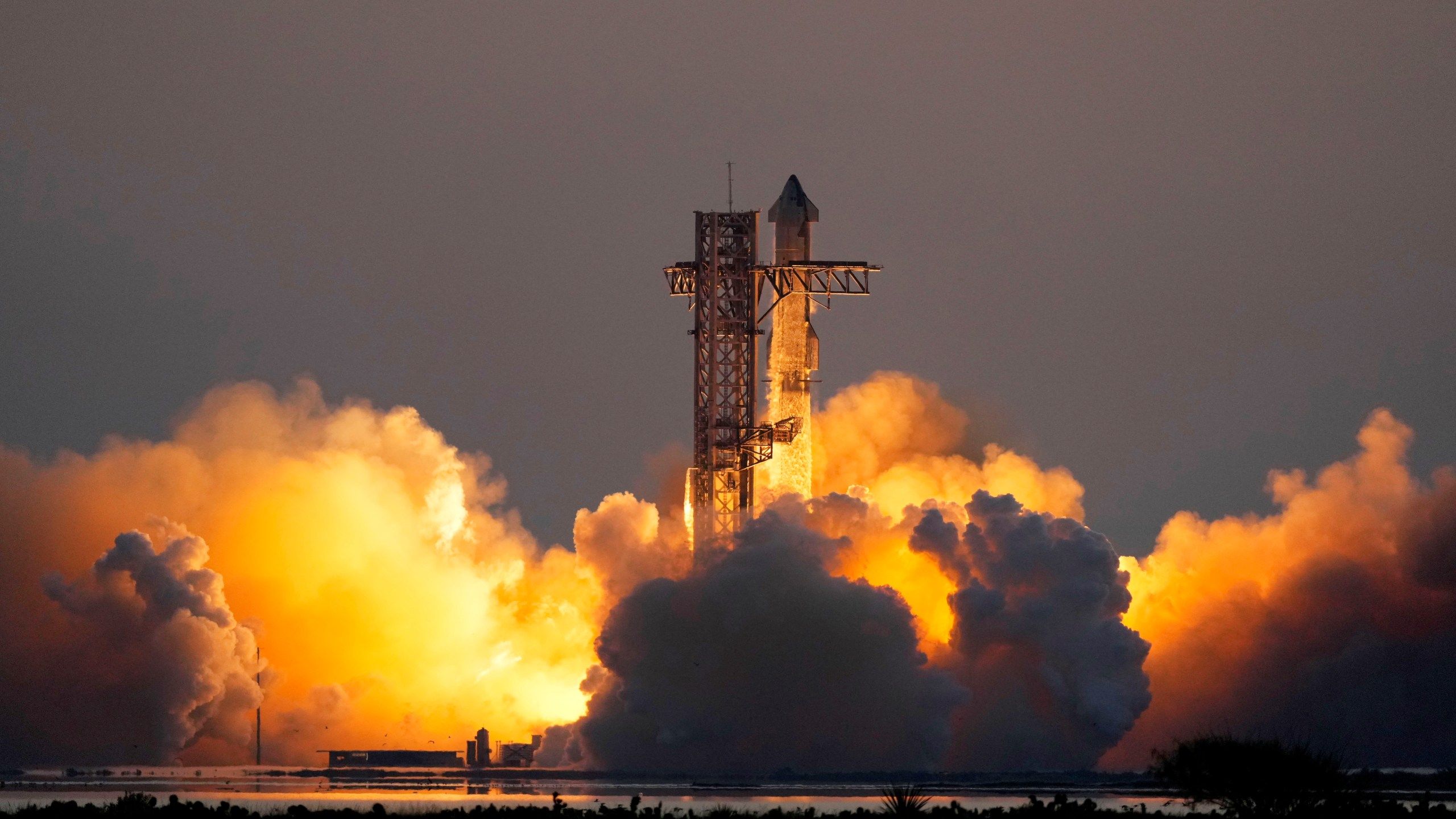 2560x1440 Mechanical SpaceX arms catch Starship rocket booster back at the launch pad