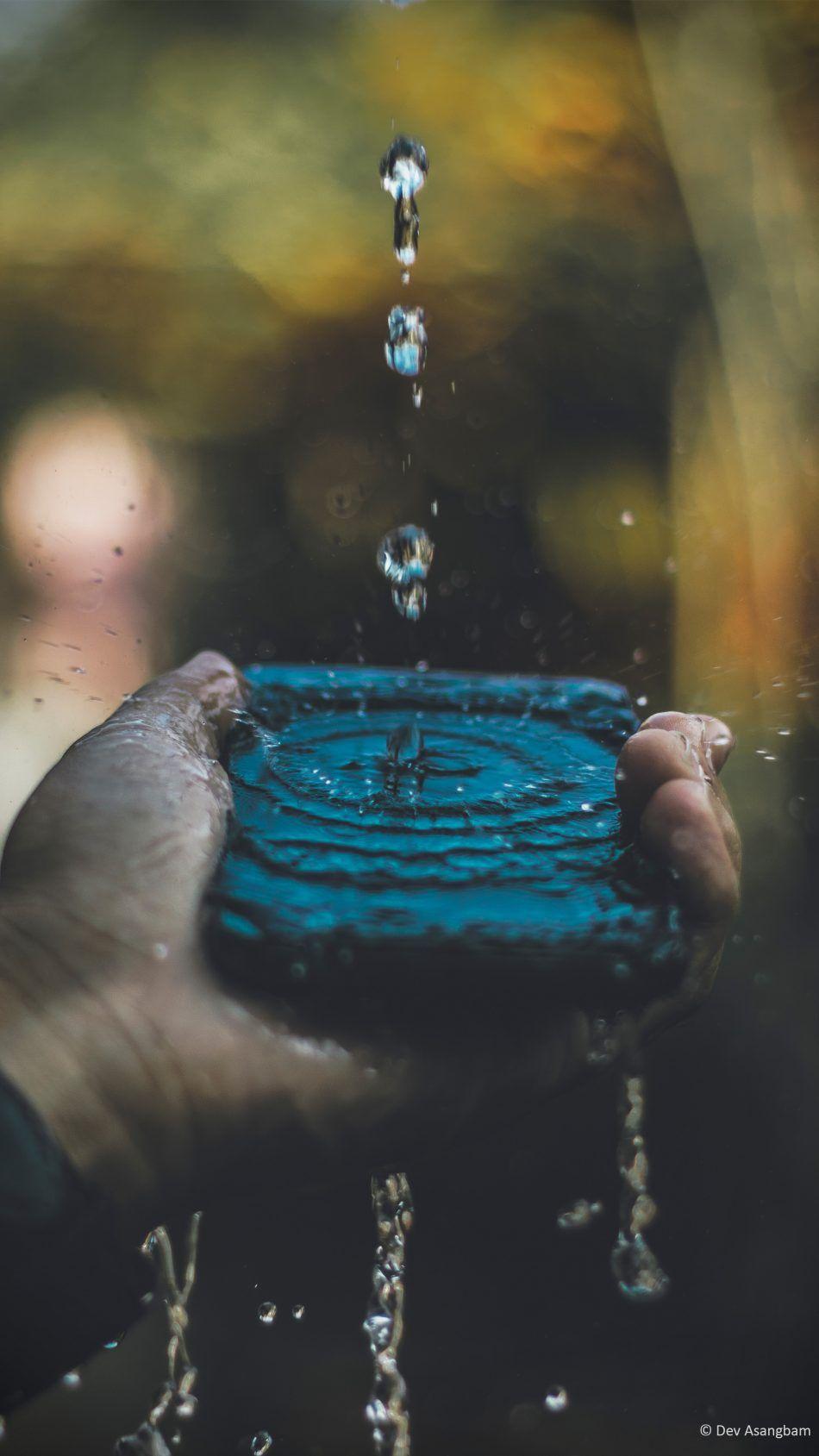 950x1689 Hand Mobile Phone Water Splash 4k Ultra HD Mobile Wallpaper