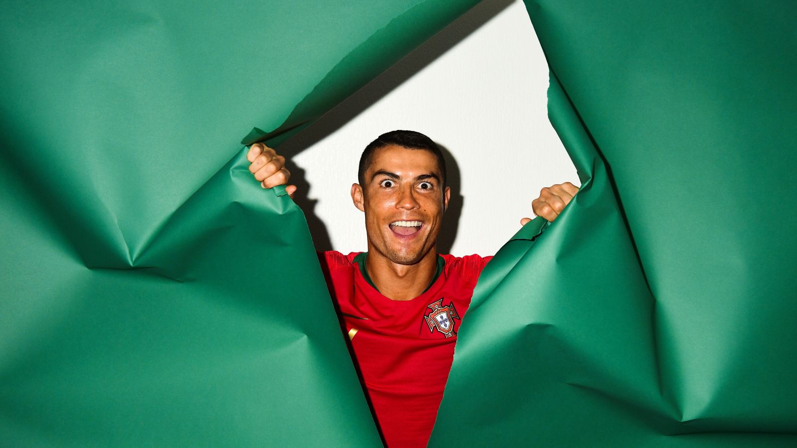 1600x900 Funny face of football player Cristiano Ronaldo on a green background Desktop wallpaper 1600x900