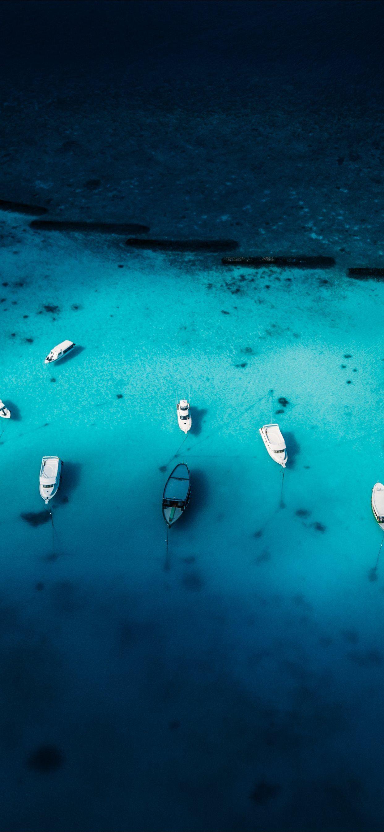 1242x2688 aerial view photography of boat on body of water iPhone X