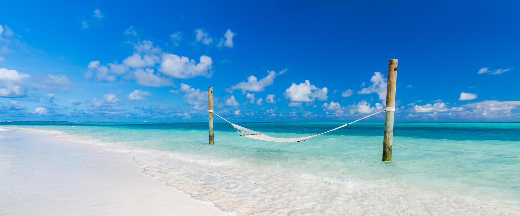 1686x700 Luxury beach. Luxury travel background. Summer vacation or holiday concept on tropical beach, white sand and an amazing swing or hammock over blue sea with horizontal view. Luxurious holiday resort 15885782 Stock