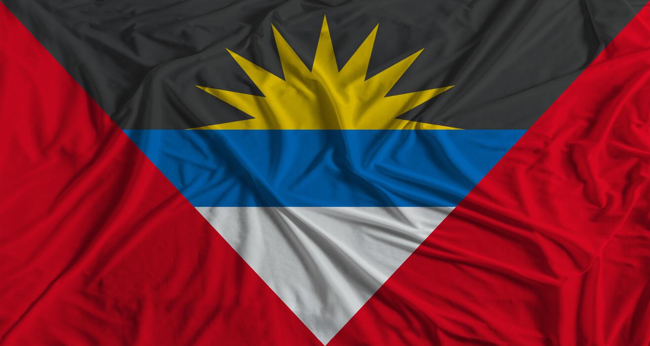1315x700 Antiguan flag with fabric texture background. National flag of Antigua and Barbuda