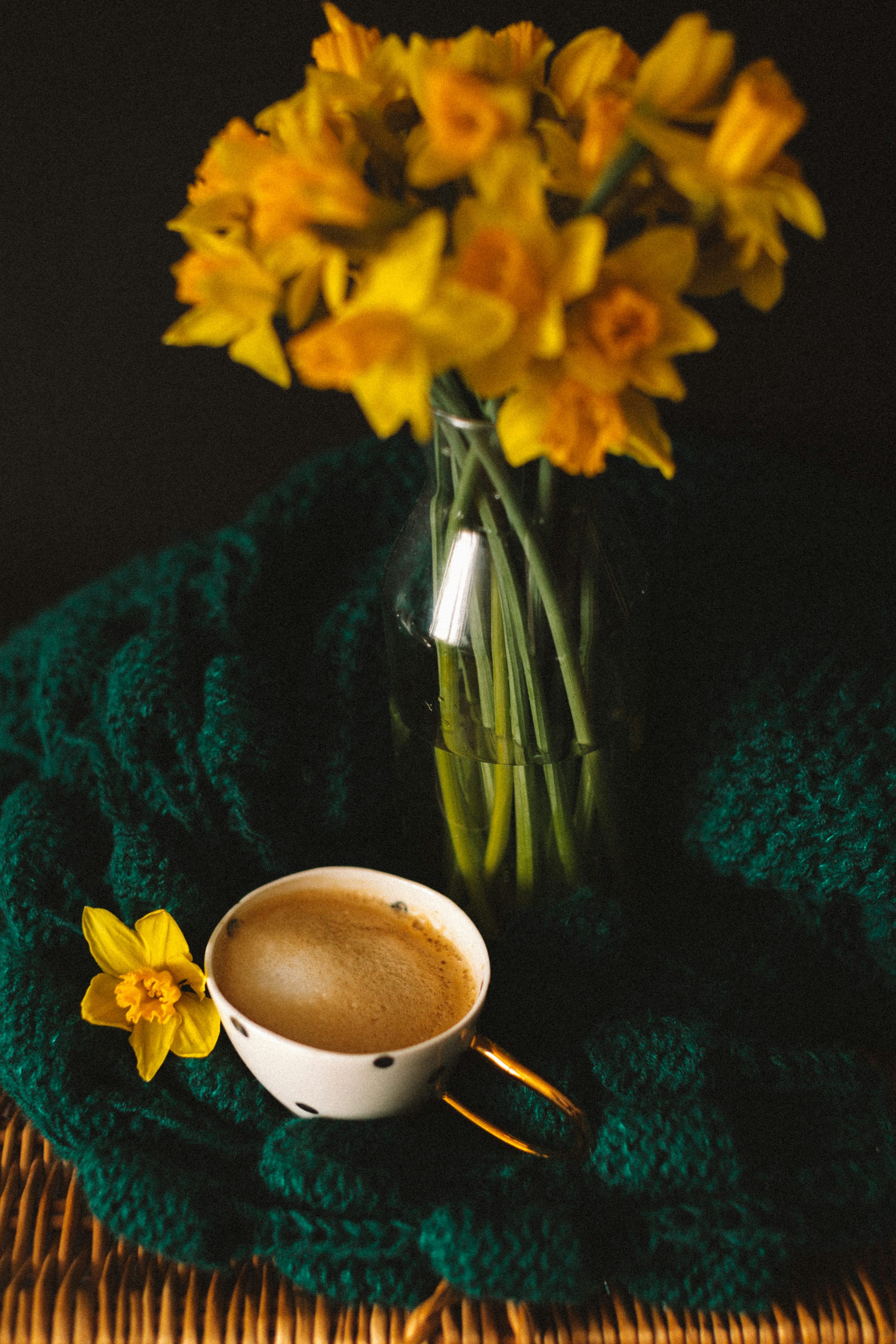3000x4500 A cup of coffee sitting on top of a table next to a vase of flowers photo