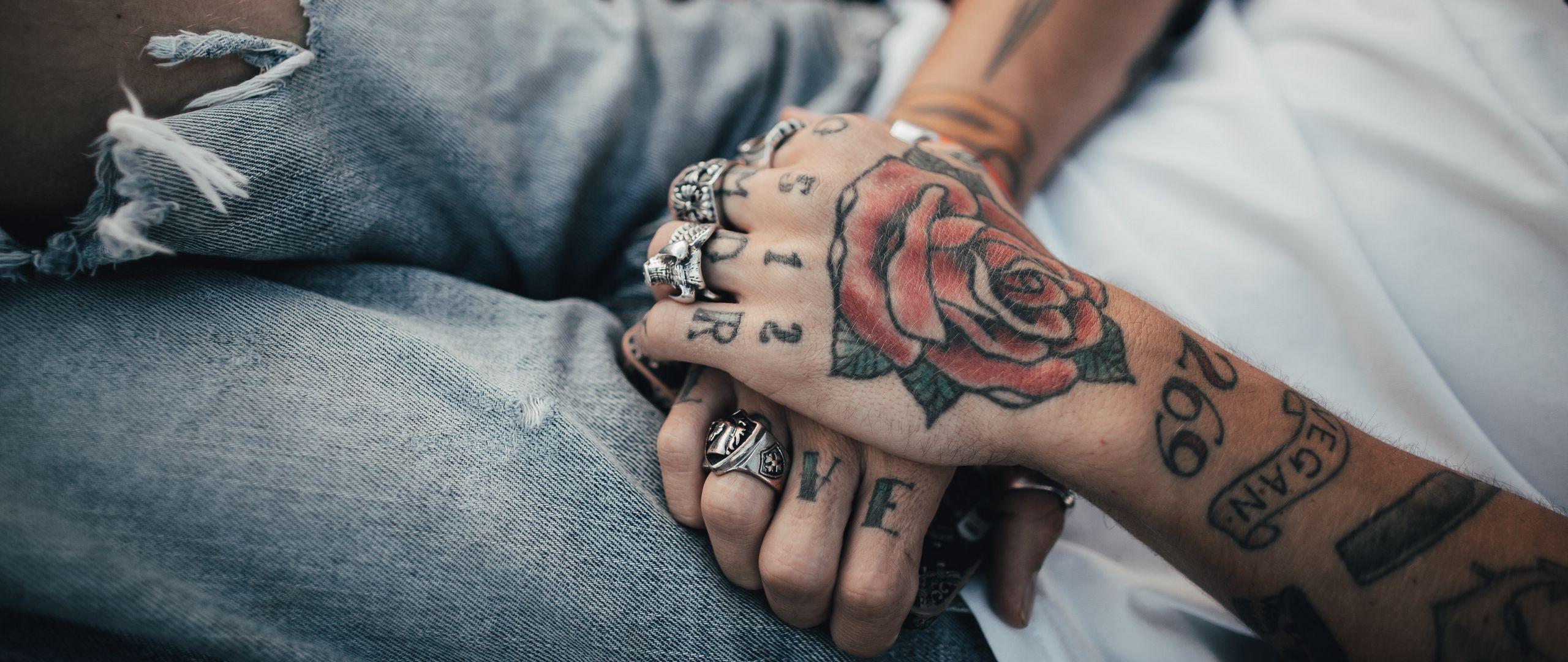 2560x1080 Download wallpaper 2560x1080 hands, tattoos, rings, decorations
