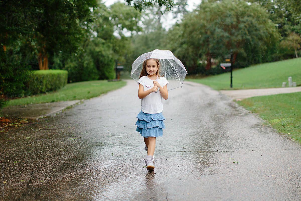 1200x800 Cute young girl out walking in the rain with an umbrella
