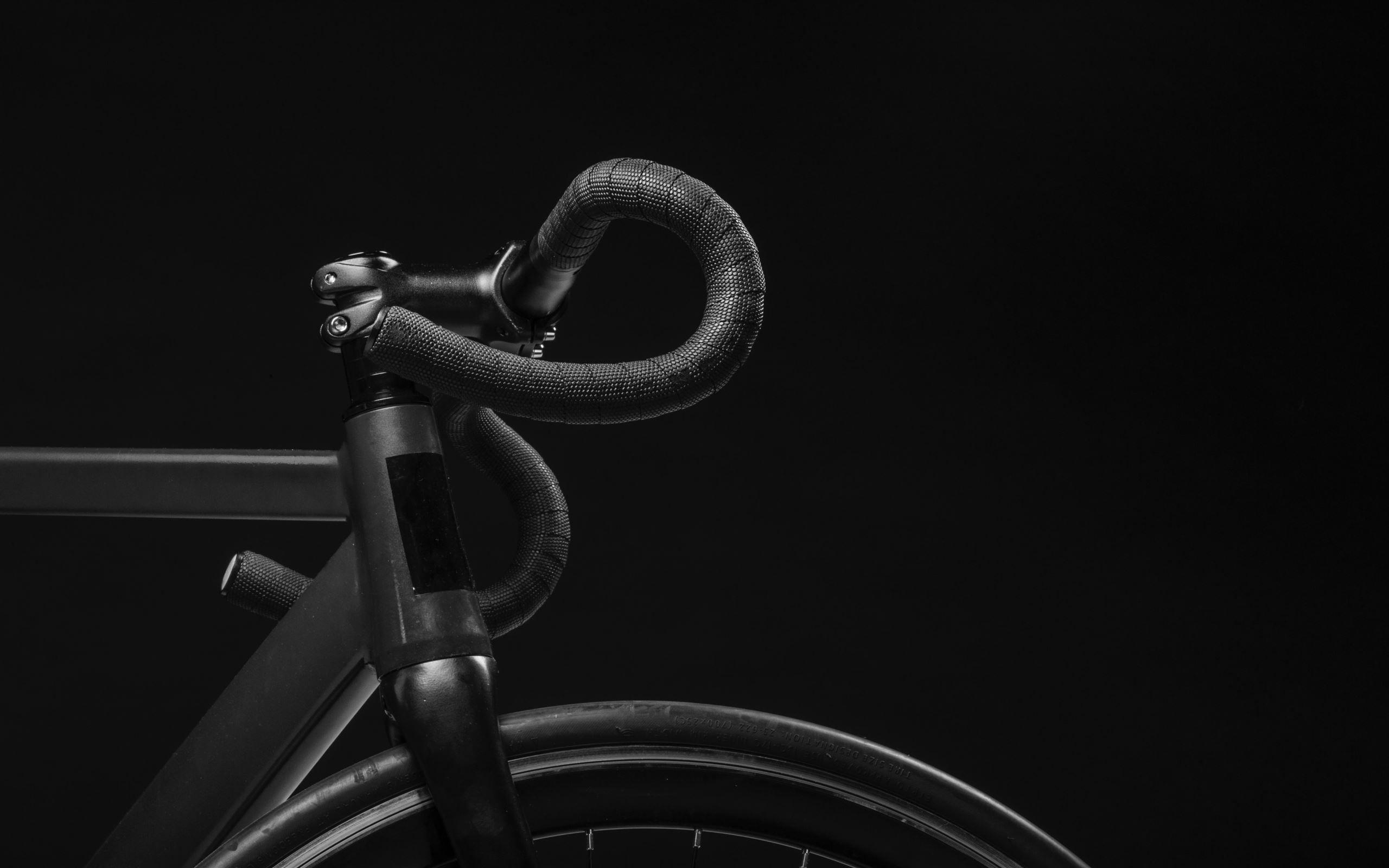 2560x1600 black road bicycle handle with black background Mac Wallpaper
