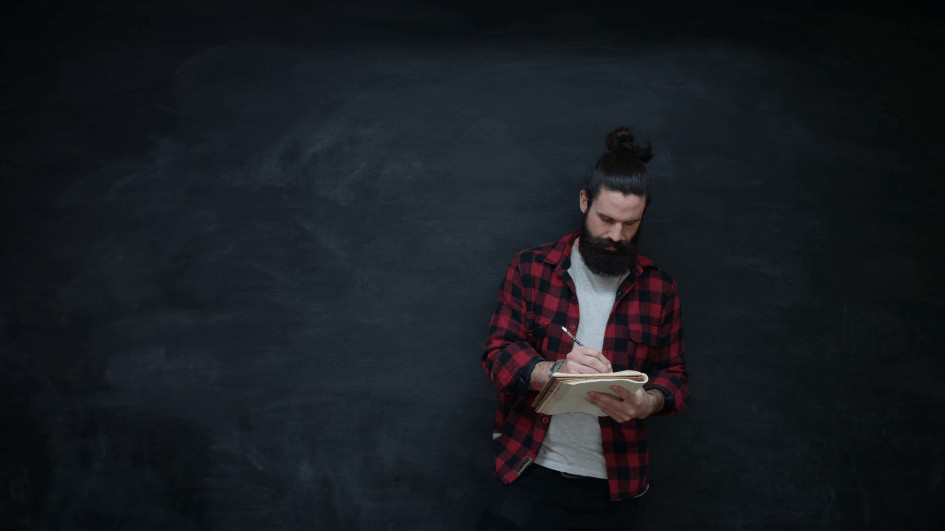 1920x1080 4K Thinking hipster man writing in notebook on chalkboard background