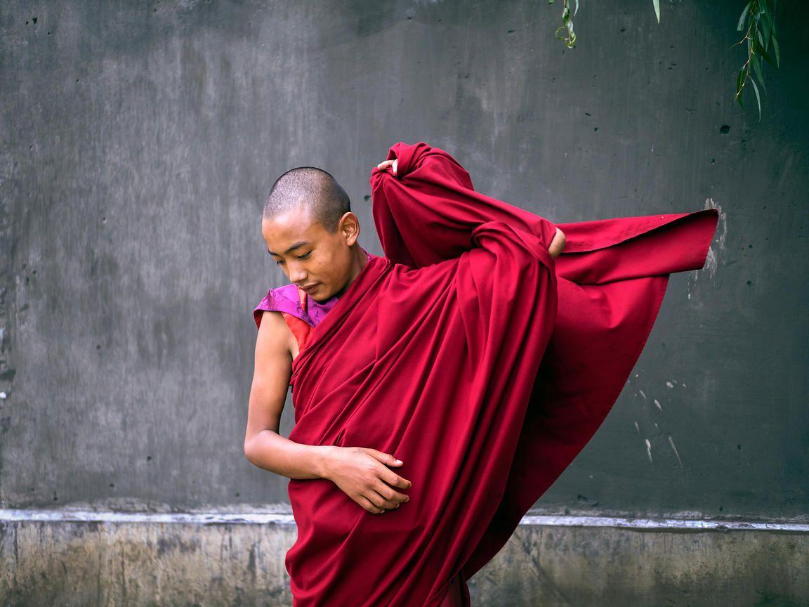1152x864 image By Abhishek. A young Buddhist monk adjusts his robe. This