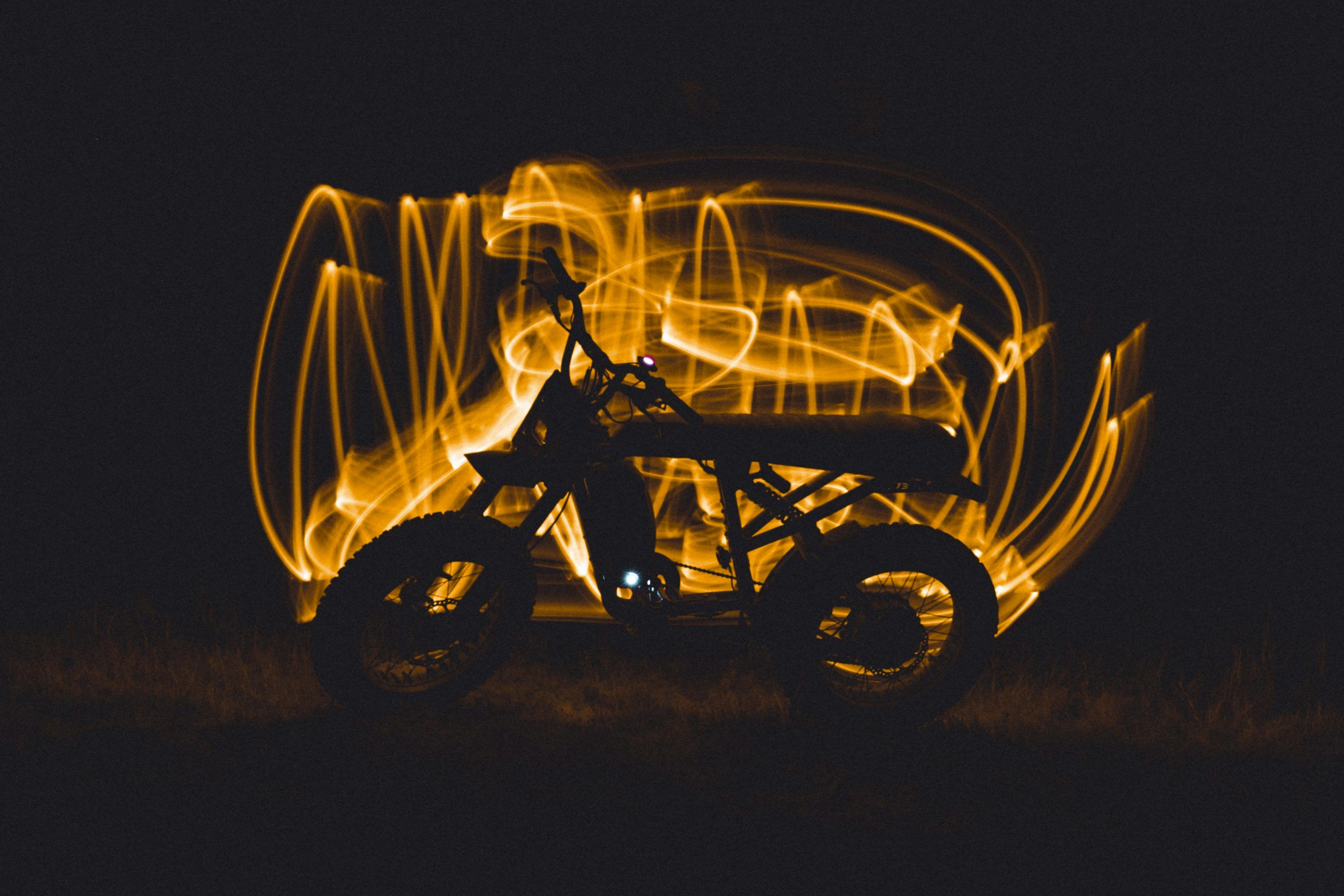 3000x2000 A motorcycle is lit up in the dark photo