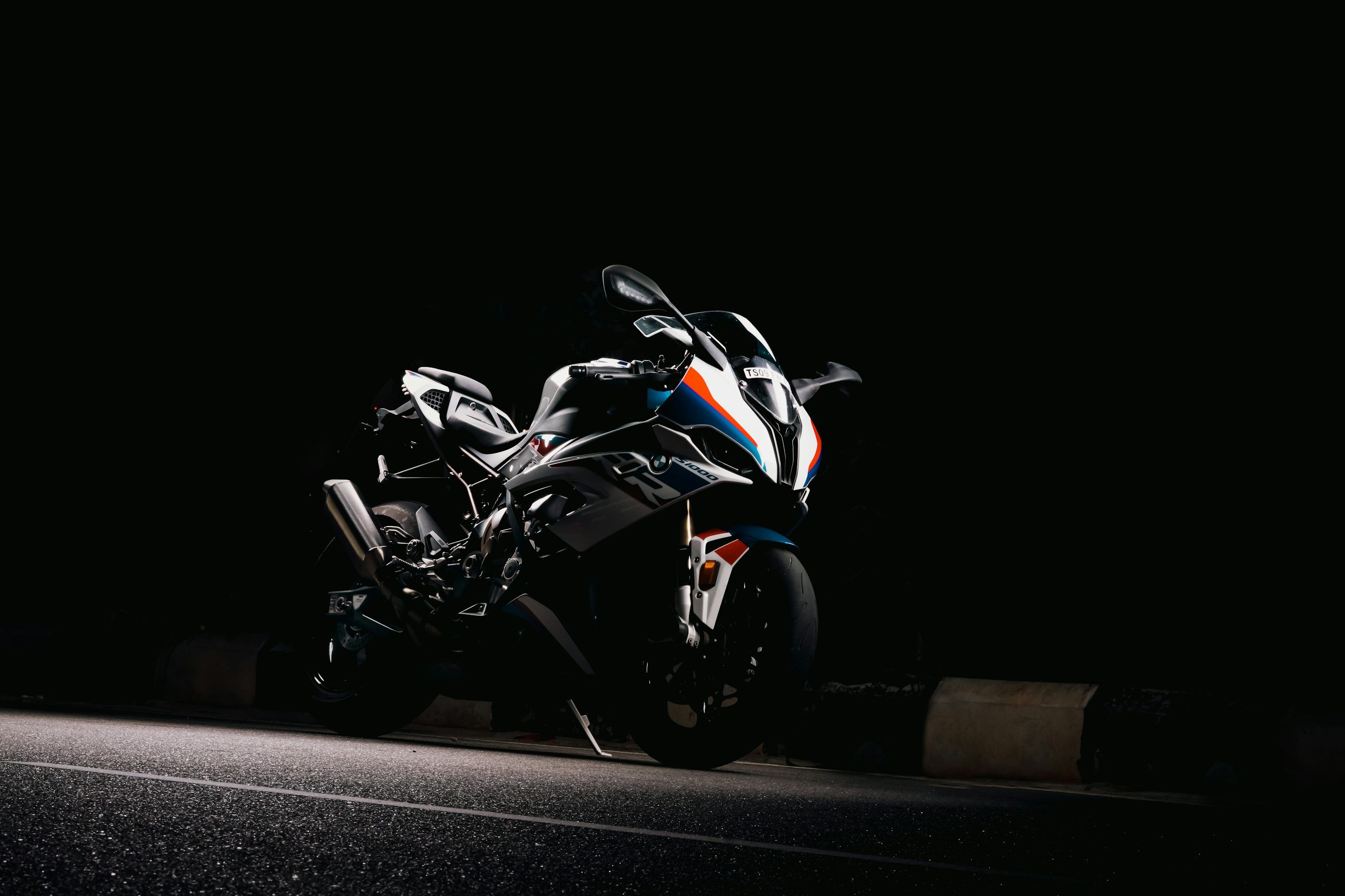 3000x2000 A motorcycle parked on the side of a road at night photo