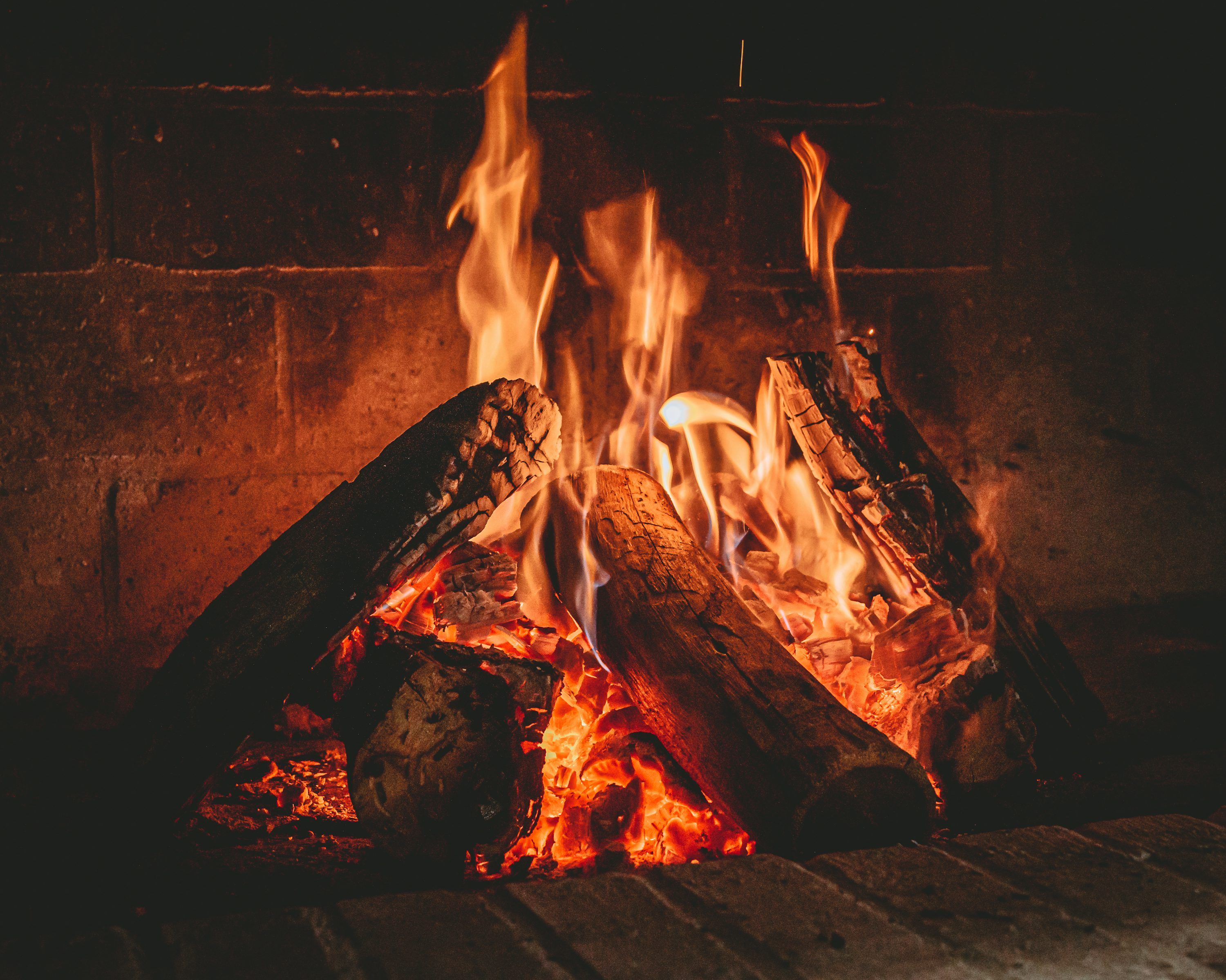 3000x2400 A warm fire burns in a brick fireplace. photo