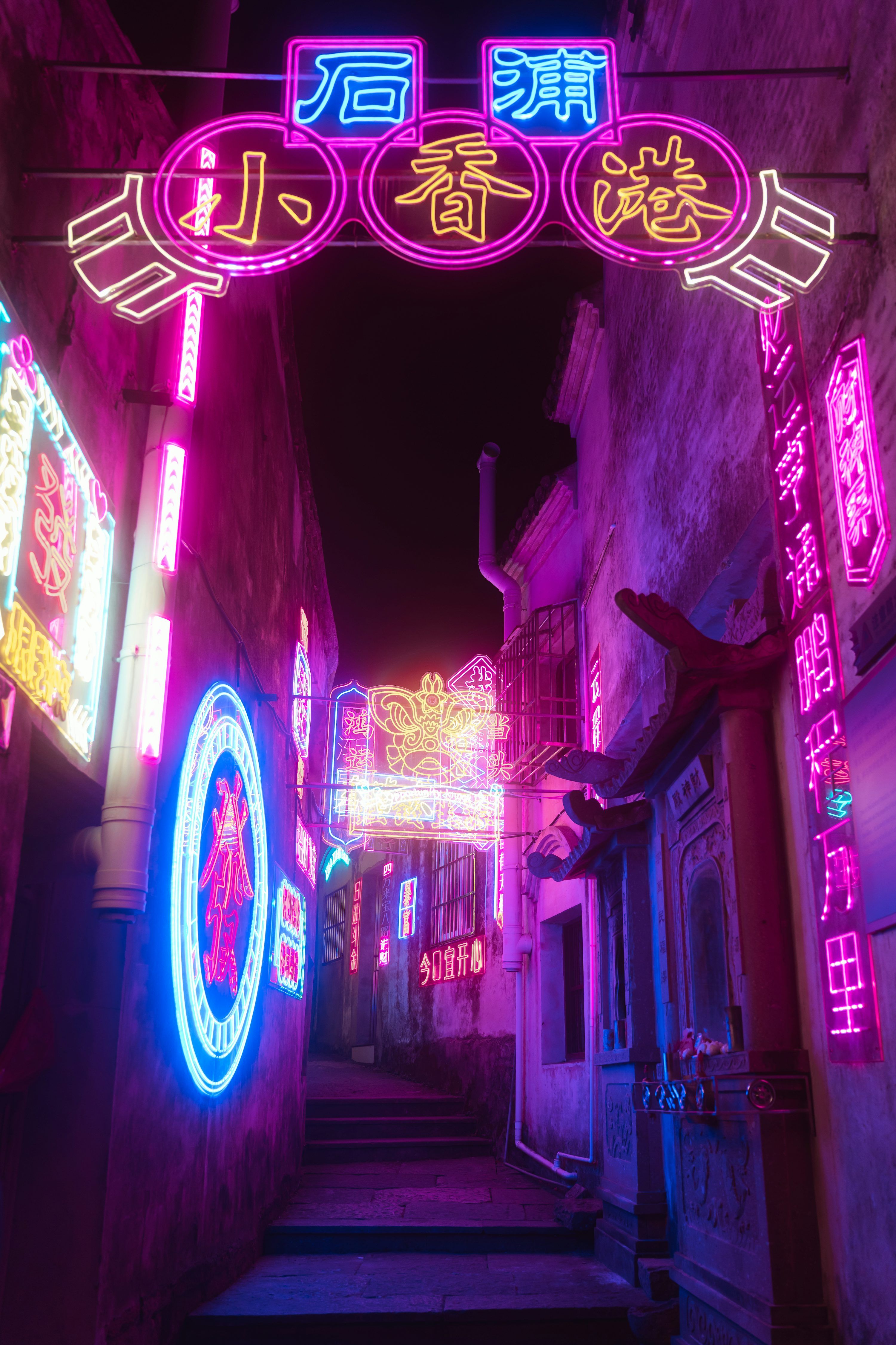3000x4500 A narrow alley way with neon signs hanging from the ceiling photo