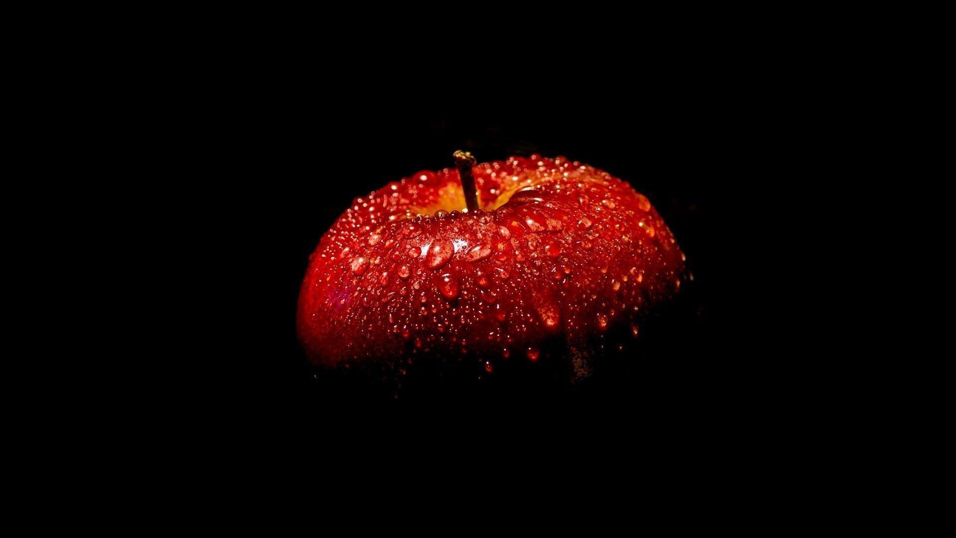 1920x1080 Red apple full with water drops in the dark. Beautiful Macro