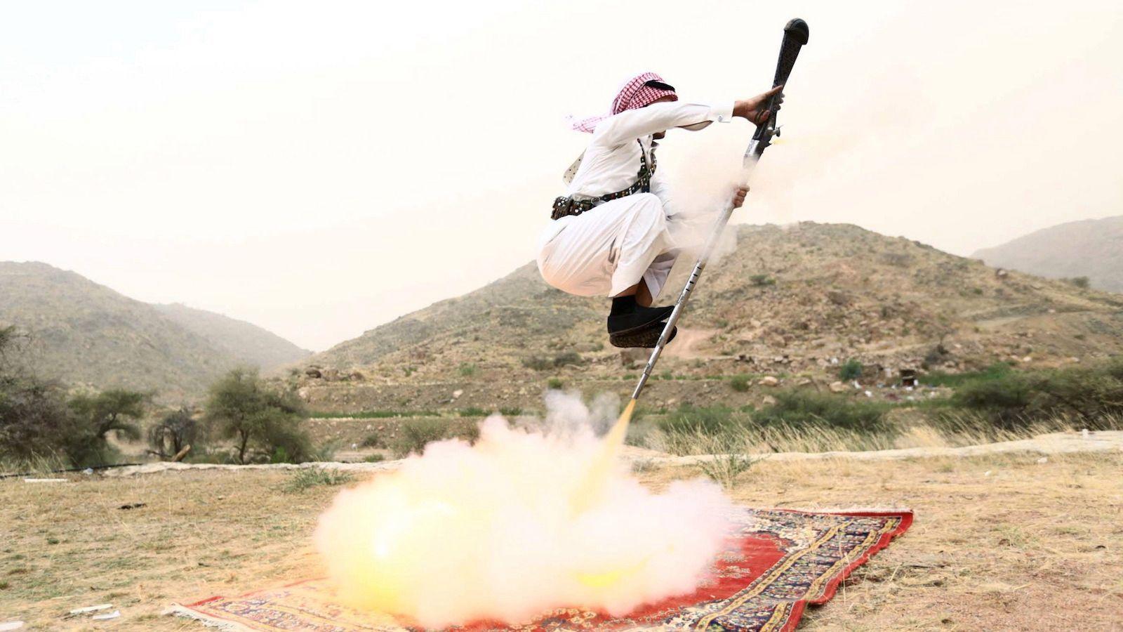 1600x900 Saudi men fly firing their rifles in stunning photo