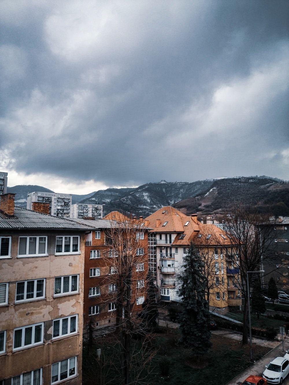 1000x1333 brown and white concrete buildings under gray clouds photo