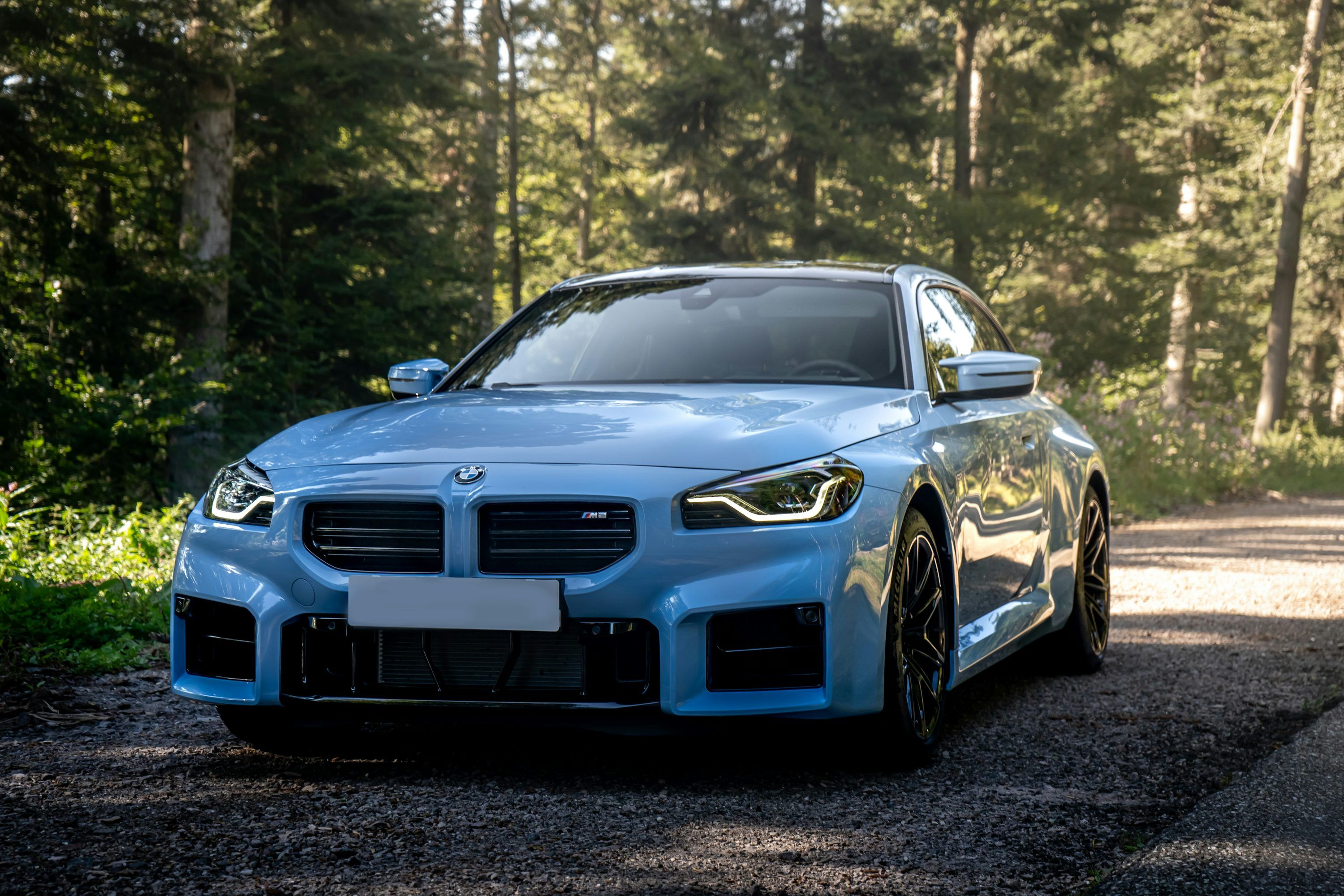 3000x2000 A light blue sports car parked on a forest road. photo