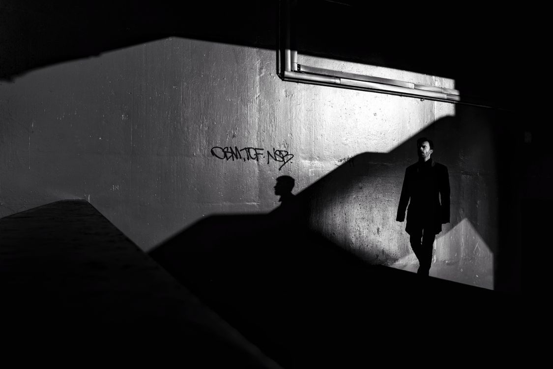 1125x750 Man Standing in the Shadow on the Background of a Wall · Free