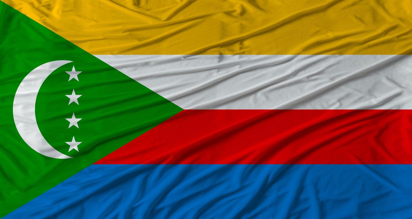 1315x700 Comorian flag waving. Flag of Comoros with cloth texture