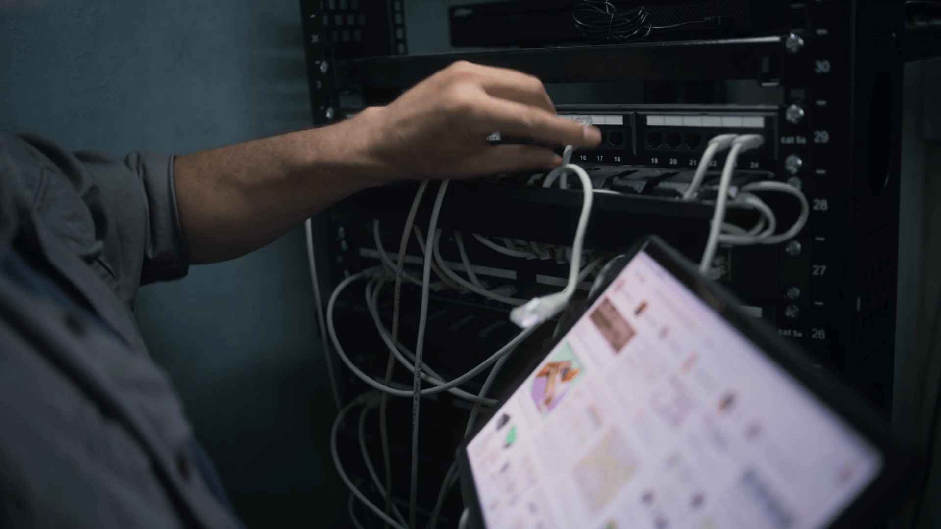 1920x1080 Male network administrator works in server room using tablet computer. Mature specialist inserts cable into server rack. Maintenance of