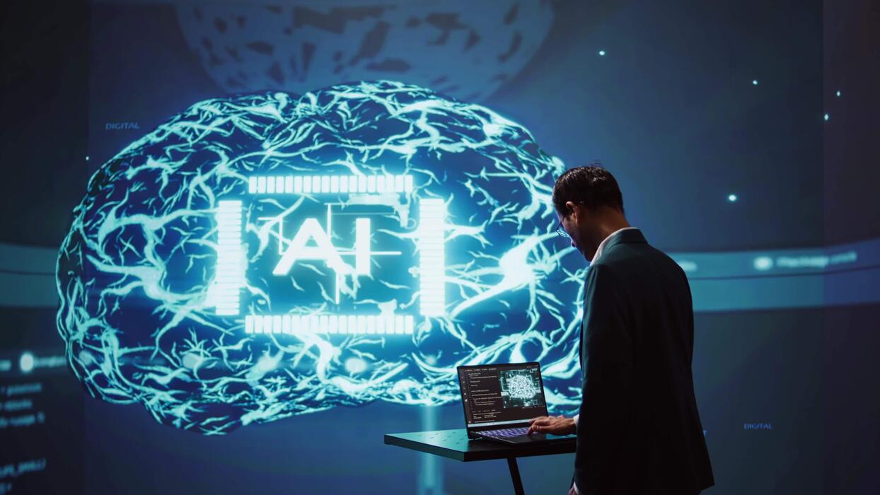 1244x700 System administrator uses neural networks modeled after human brain to solve complex problems. AI researcher in futuristic workspace using artificial intelligence to look at data, camera B