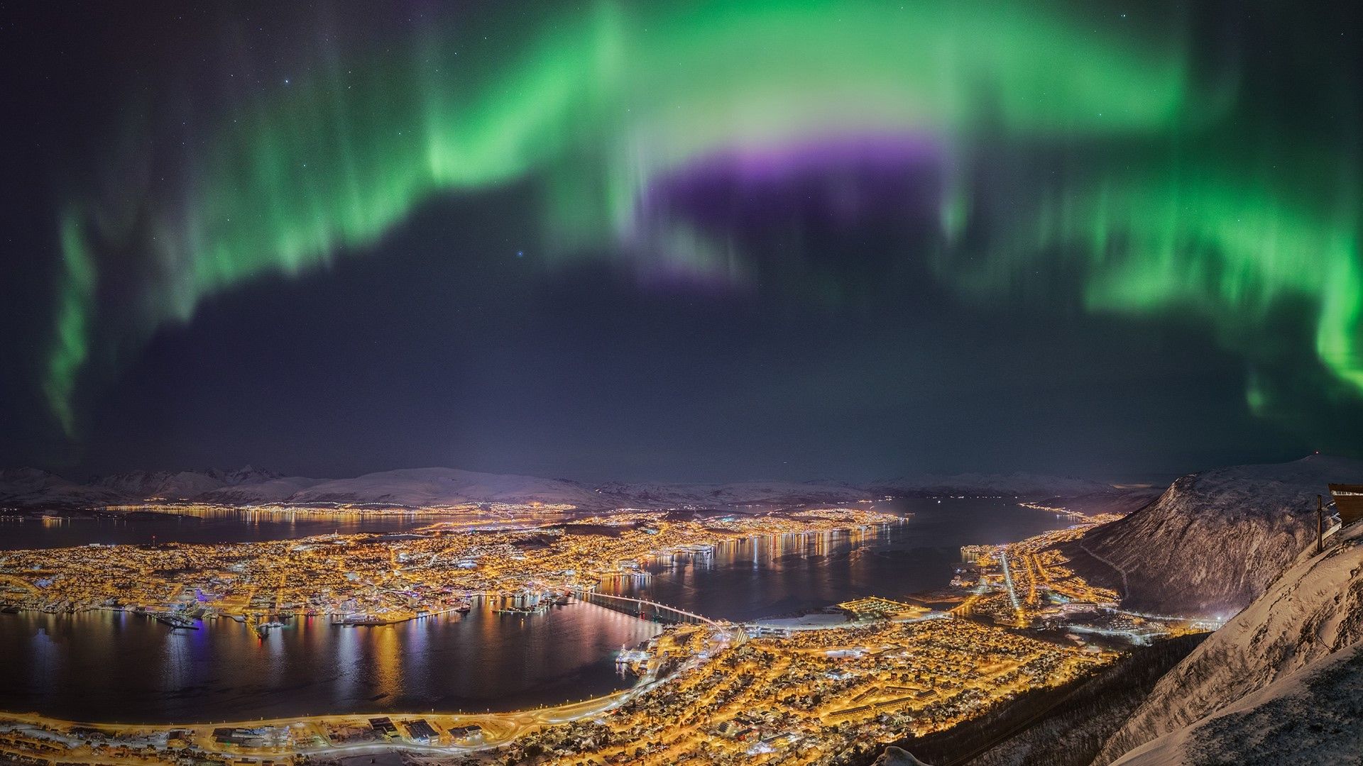 1920x1080 Northern lights dancing over the city of Tromsø, Troms, northern Norway. Windows Spotlight Image