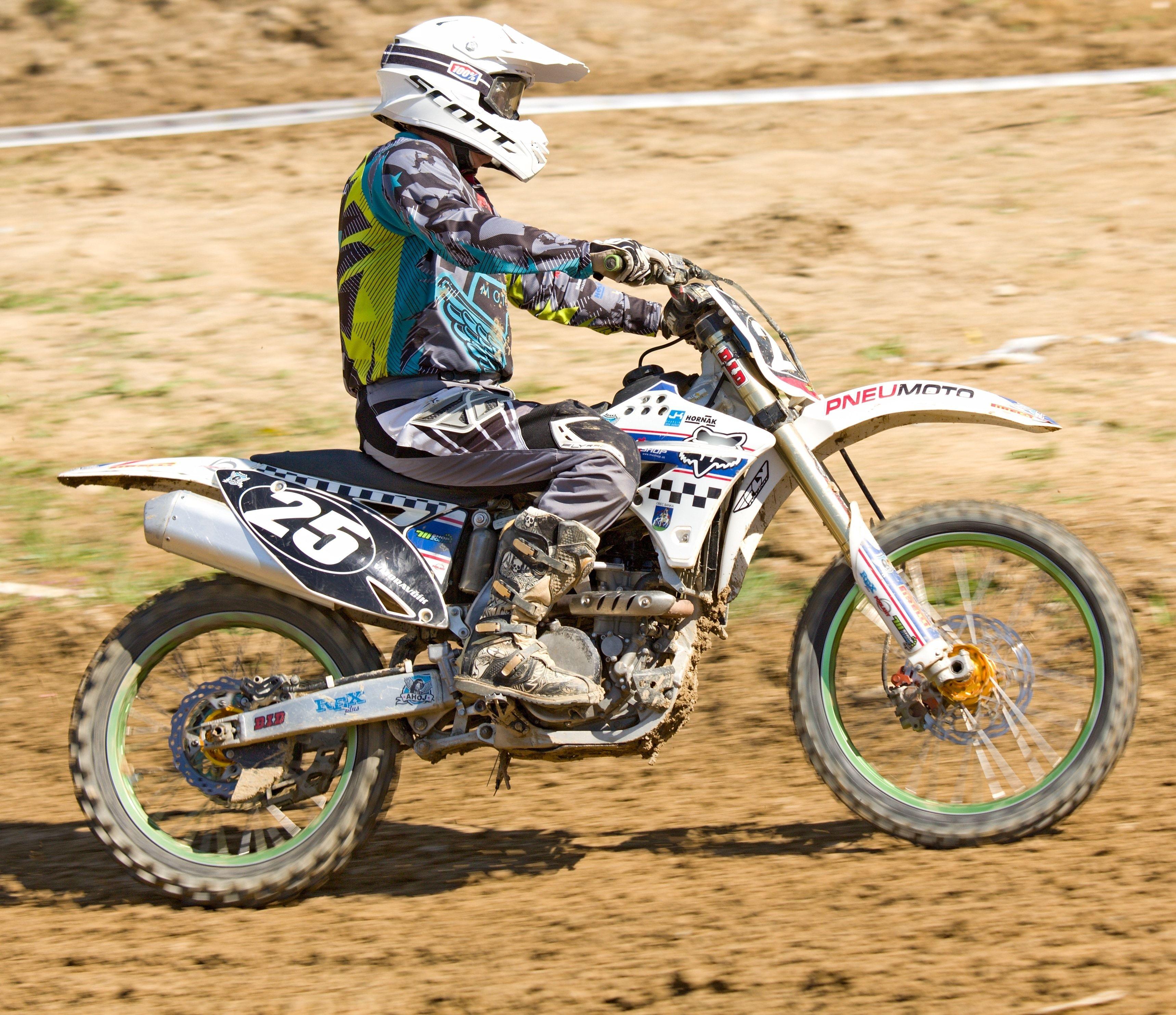 3437x2966 man in black, green and white motocross gear riding on white