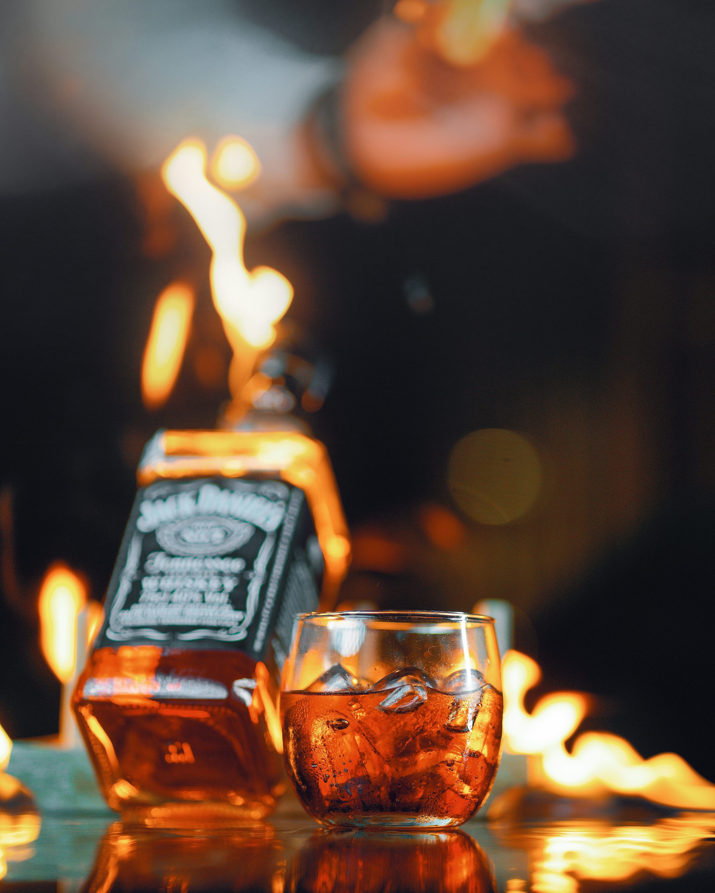 3000x3743 Jack daniel's whiskey bottle and glass by a fire. photo