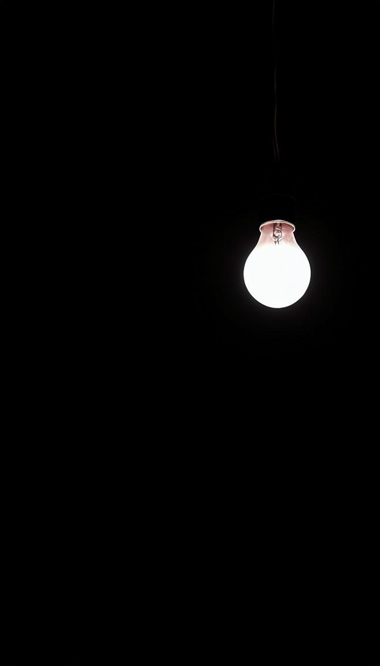 768x1344 Minimalist Incandescent Light Bulb Against Black Background Mobile Wallpaper